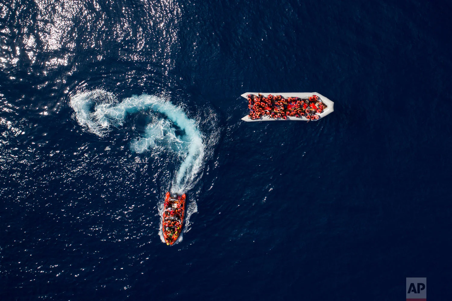 Refugees and migrants are rescued by members of the Spanish NGO Proactiva Open Arms, after leaving Libya trying to reach European soil aboard an overcrowded rubber boat, north of the Libyan coast, on Sunday, May 6, 2018. In total, 105 refugees and migrants from various countries, including Bangladesh, Egypt, Nigeria, Marrocos, Gana, Pakistan, Sudan, Libya, Eritrea and Senegal, were rescued from the overcrowded rubber boat. (AP Photo/Felipe Dana)