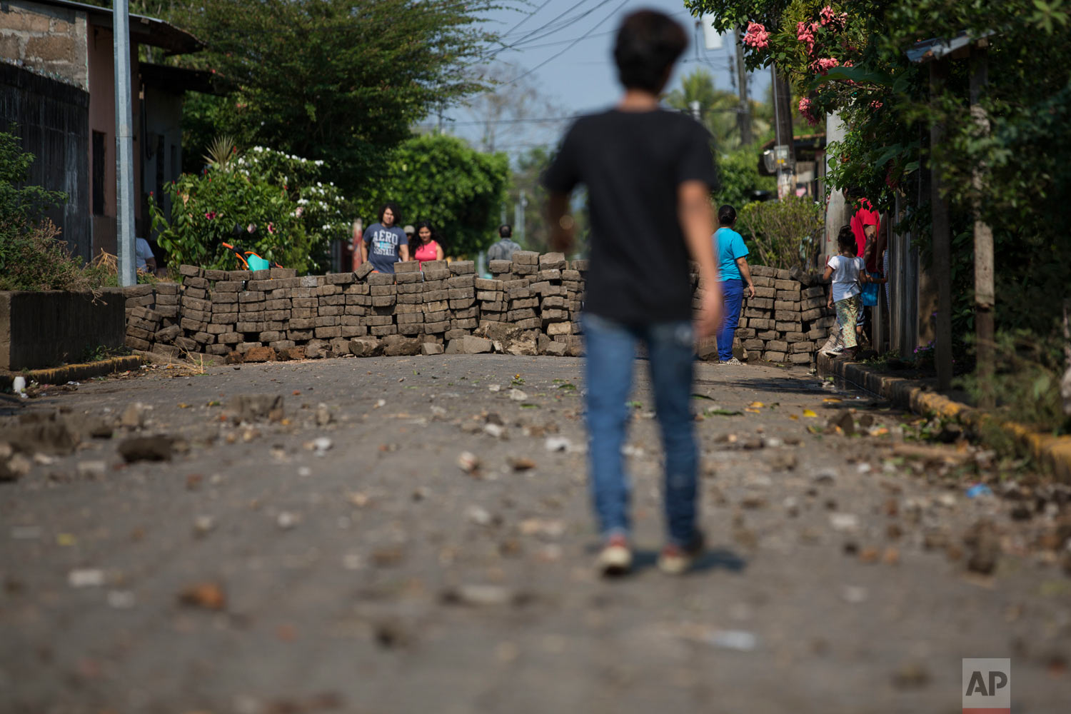 Residents walk near a road block set up by anti-government protesters in Niquinohomo, Nicaragua, on Monday, May 7, 2018, the morning after anti-government demonstrators clashed with government supporters and police. Protests in which dozens of people were killed amid a harsh crackdown by police and government-allied civilians have weakened Ortega, one of the few leftist leaders remaining in power in Latin America, forcing him to pull back on social security reforms that sparked the unrest and facing a newly emboldened opposition determined to see him leave office. (AP Photo/Moises Castillo)