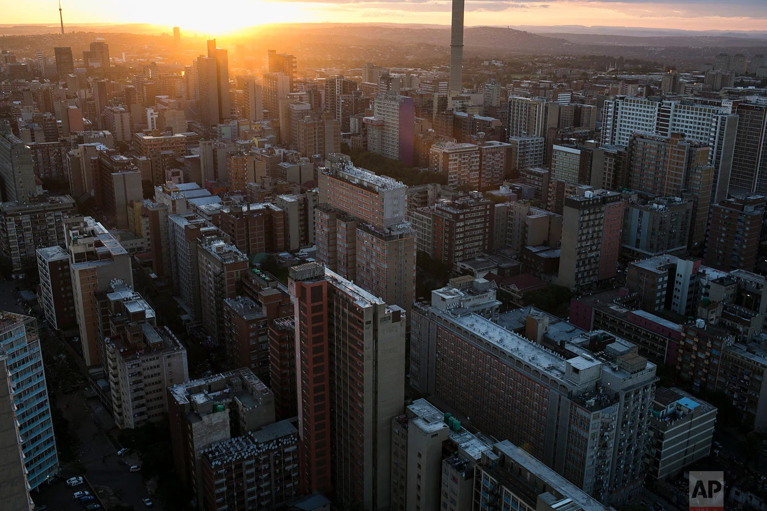 The sun sets behind downtown. April 6, 2018. (AP Photo/Bram Janssen) 