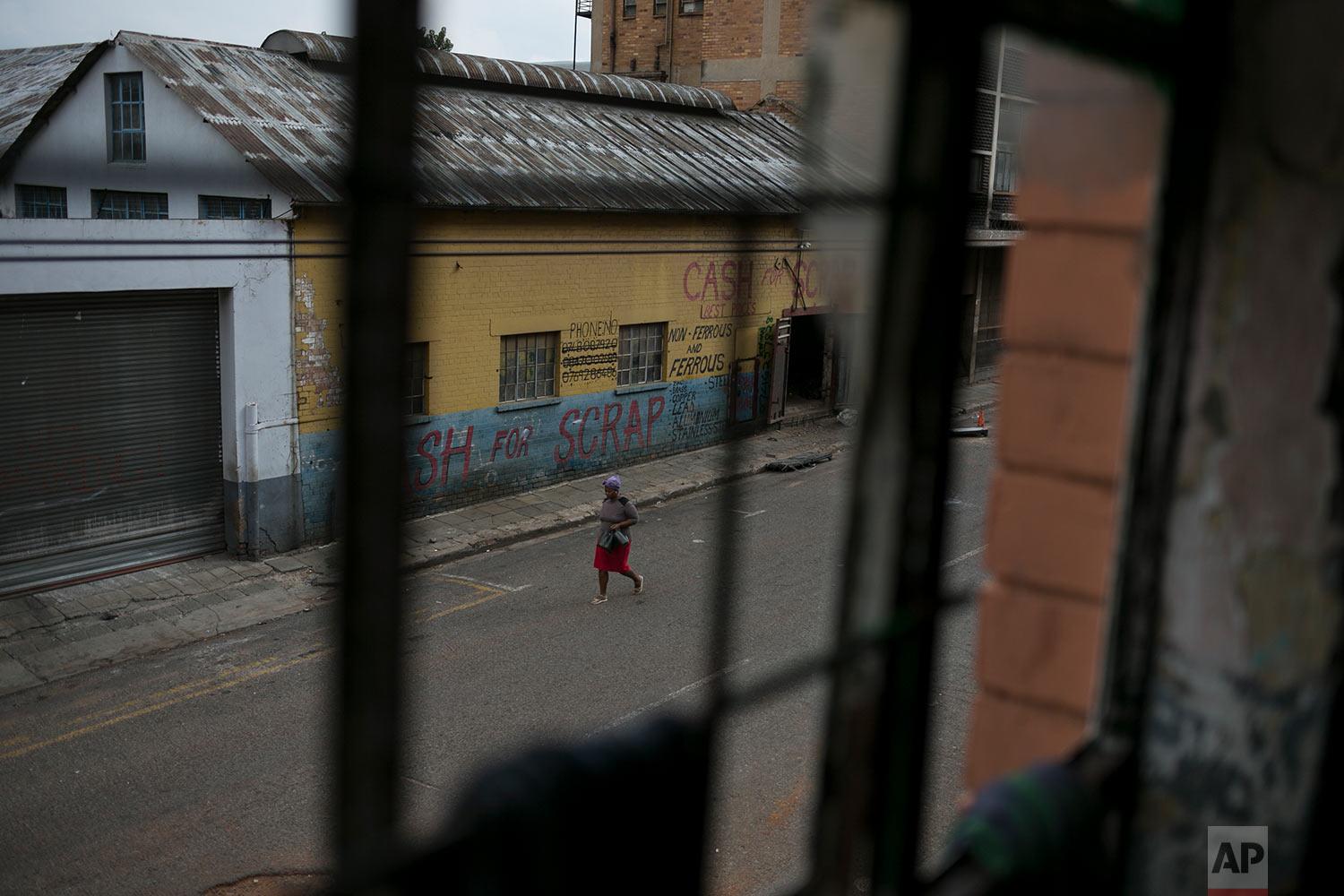  A woman walks past an abandoned building occupied by squatters. March 30, 2018. (AP Photo/Bram Janssen) 