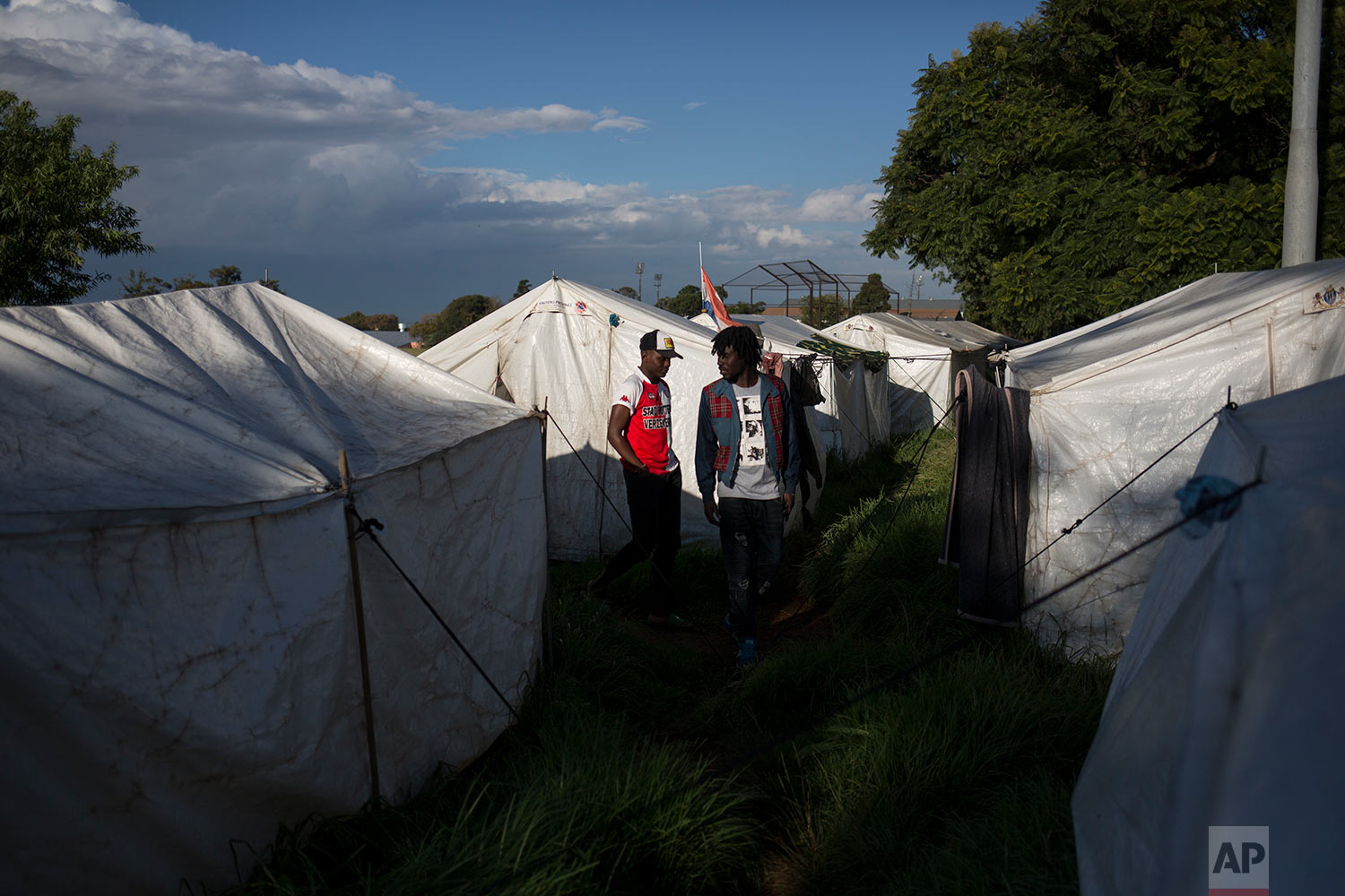  Migrants walk amid tents provided by the city government after they were evicted. April 19, 2018. (AP Photo/Bram Janssen) 