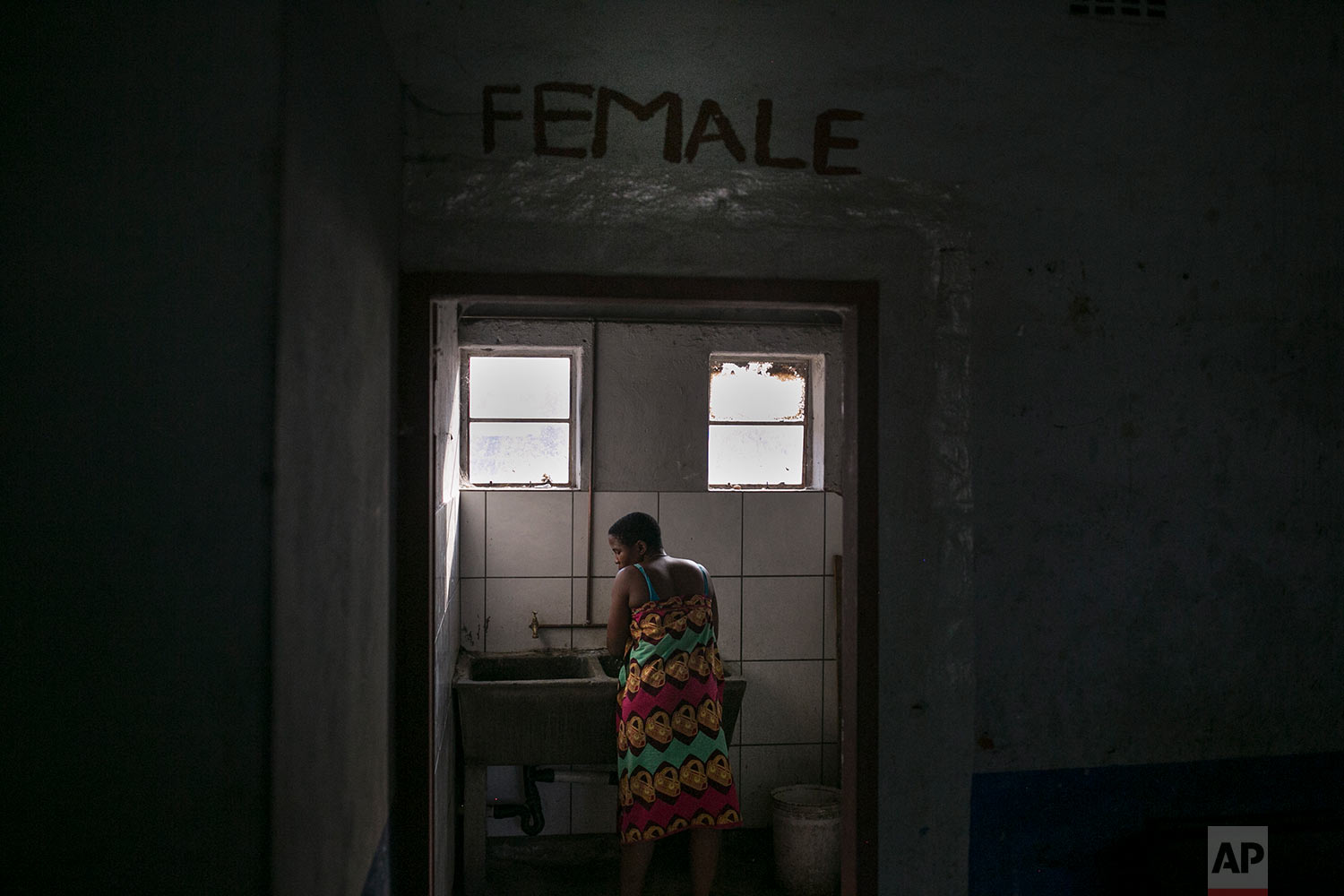  A woman washes clothing in the bathroom of an occupied building. March 29, 2018. (AP Photo/Bram Janssen) 