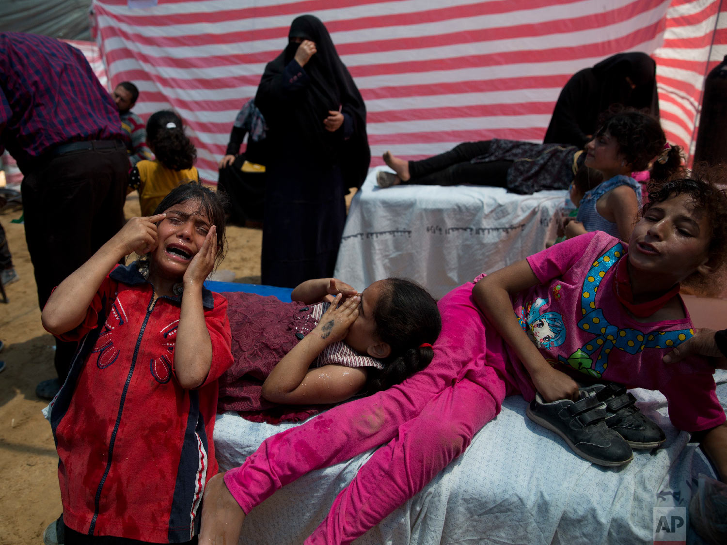 Palestinian children suffering from teargas inhalation recover in a medical tent during a protest near Beit Lahiya, Gaza Strip, Monday, May 14, 2018.(AP Photo/Dusan Vranic)