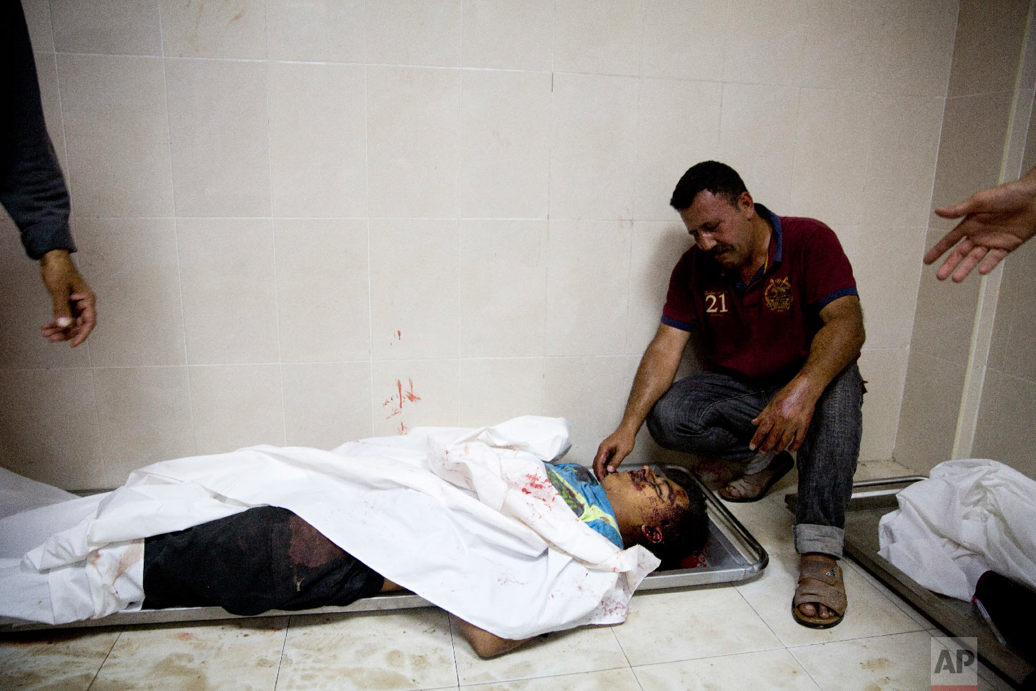 A relative of a Palestinian killed during a protest on the border with Israel mourns over his body in a morgue in Beit Lahiya, Gaza Strip, Monday, May 14, 2018. (AP Photo/Dusan Vranic)
