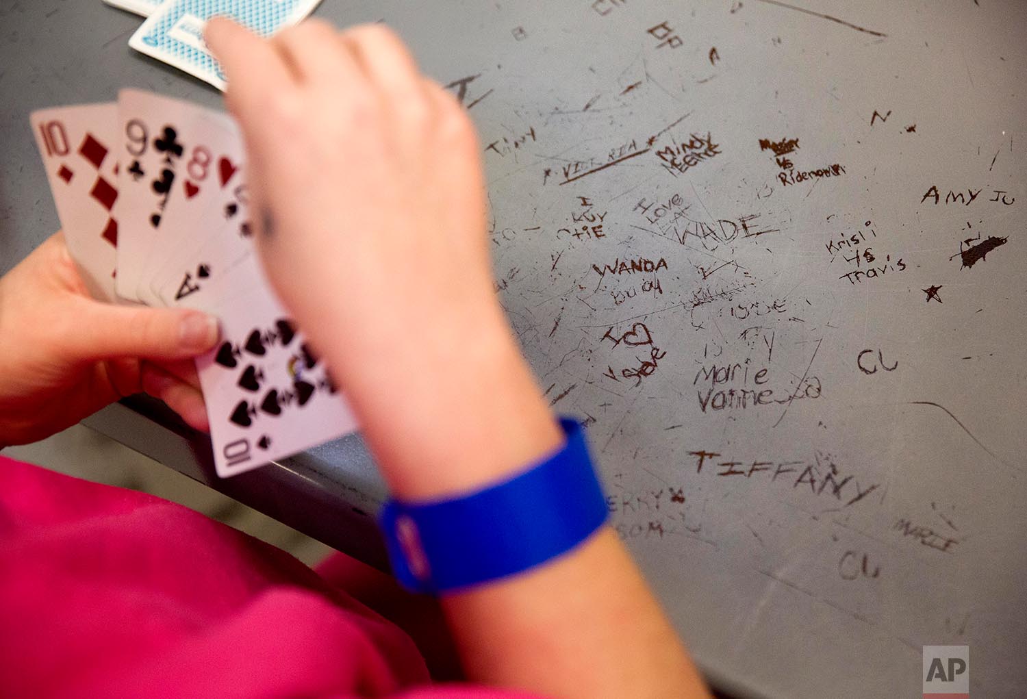  Names are etched in a metal table as inmates play cards in the Campbell County Jail in Jacksboro, Tenn., Thursday, March 15, 2018. (AP Photo/David Goldman)    