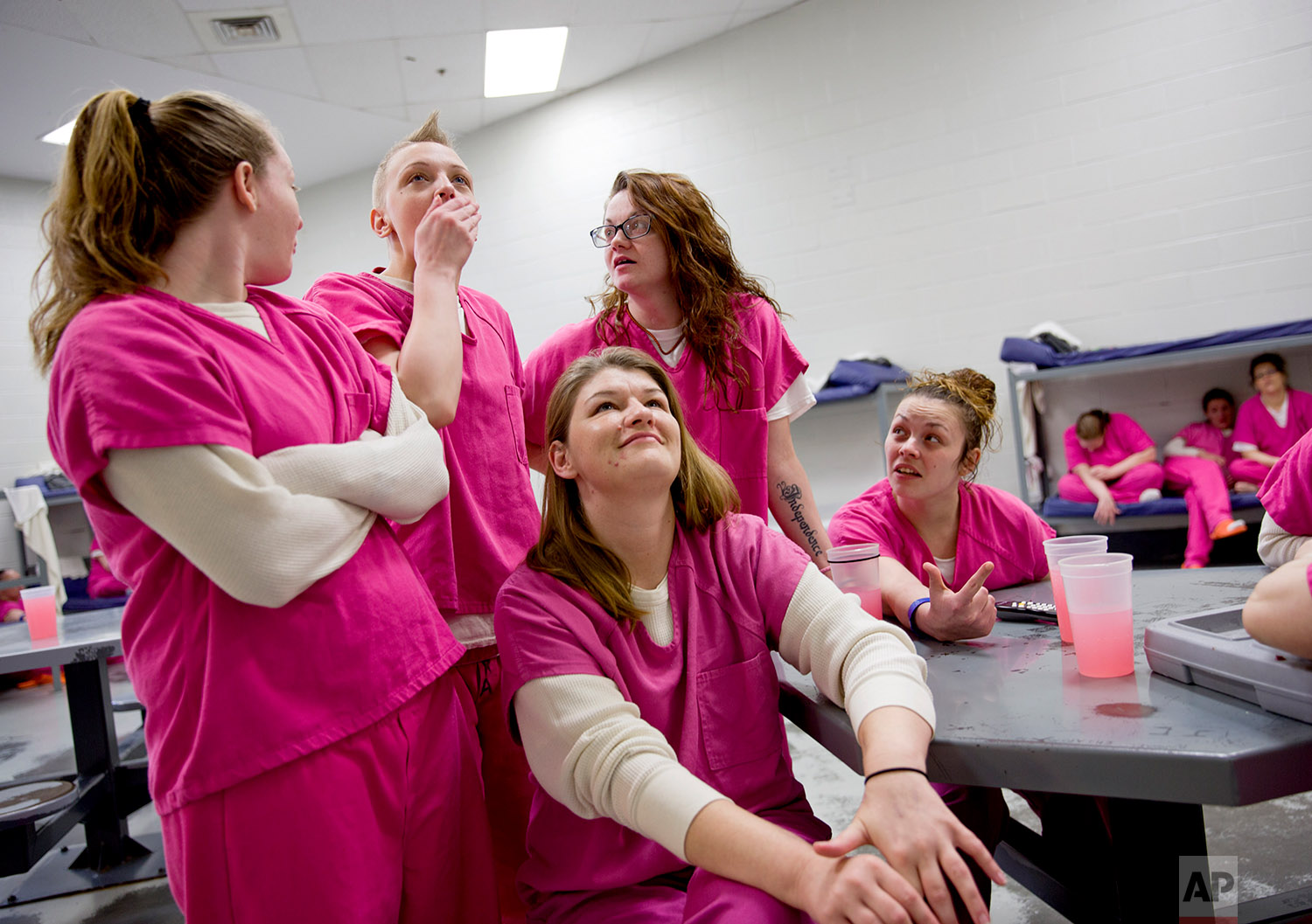  Tara White, second from left, reacts to hearing that her cousin was arrested, while watching the local news in her cell at the Campbell County Jail in Jacksboro, Tenn., Tuesday, March 20, 2018. Every evening around dinner time inmates gather around 