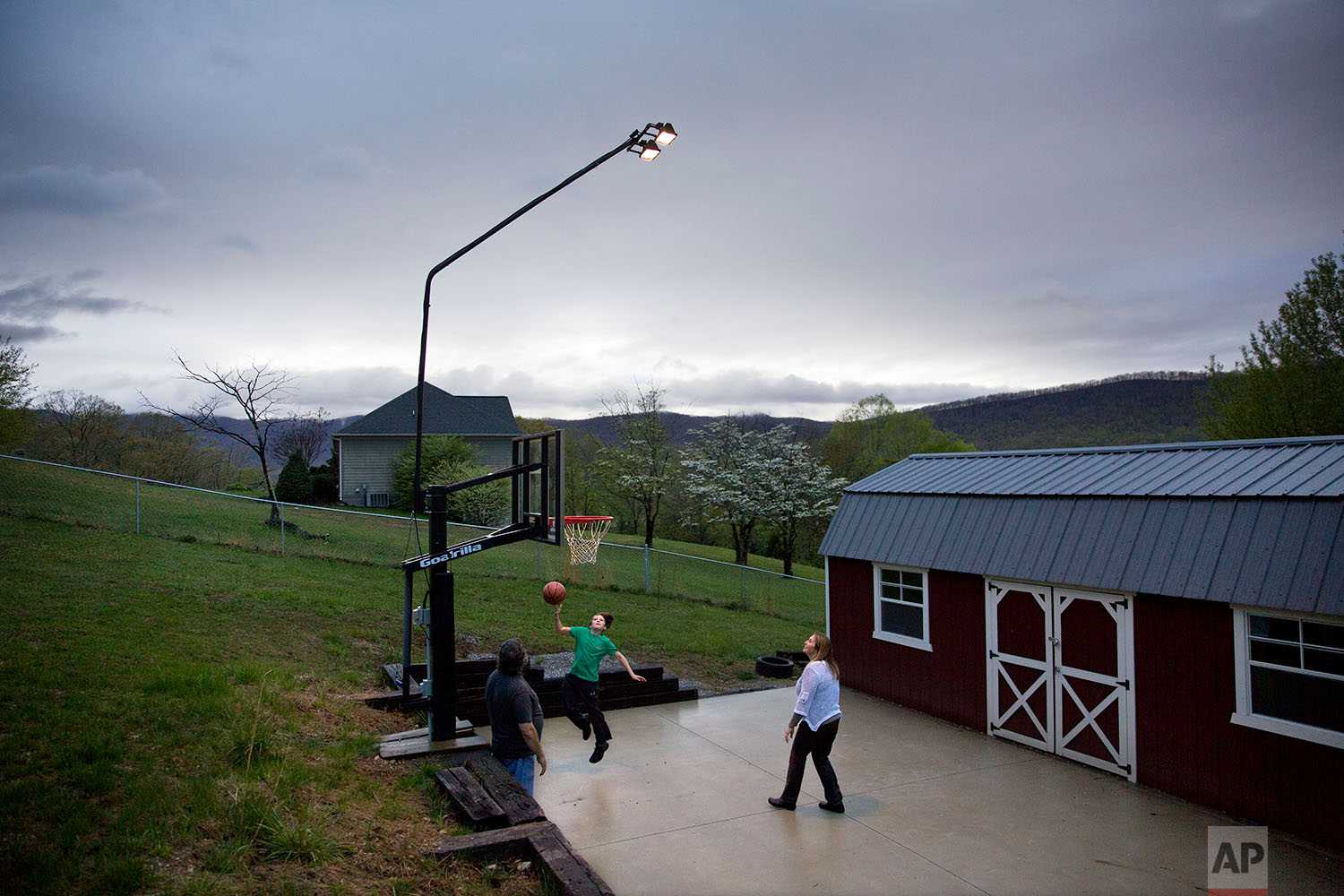  Robby Wilson, 10, plays basketball with his grandparents Cathy, right and Eddy Sweat, who have custody of him as their daughter, Robby's mother, Krystle Sweat, sits in jail in Jacksboro, Tenn., Monday, April 23, 2018. (AP Photo/David Goldman)    