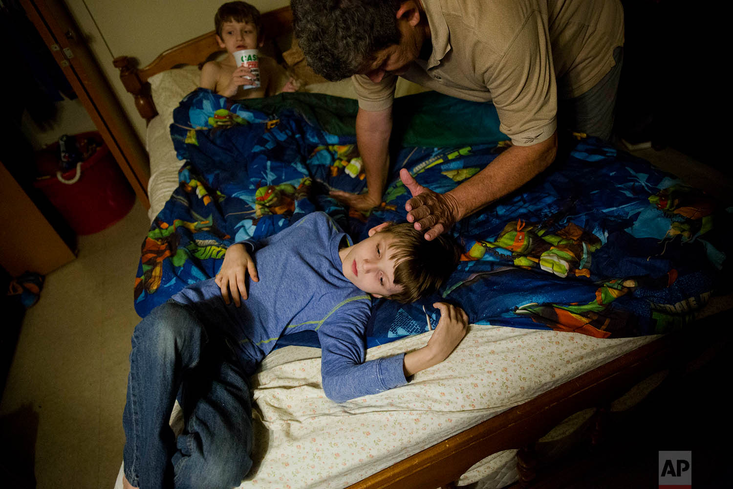  Danny Peters gets his sons Journey, 10, and Chance, 8, ready for bed in LaFollette, Tenn., Wednesday, March 28, 2018, as he cares for them while his ex-wife and the boys' mother, Crystal French, serves time in the Campbell County Jail. (AP Photo/Dav