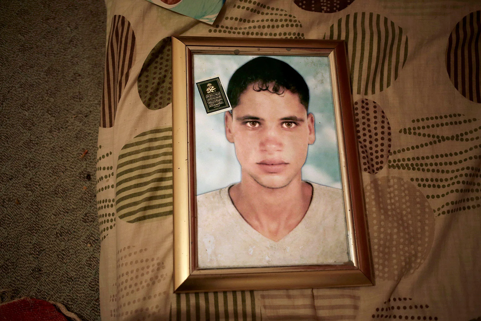 This Thursday, April 12, 2018 photo shows a framed portrait of Radya Jejli, who went missing in 2011, in his bedroom in the town of Ras Jebel, Tunisia. (AP Photo/Nariman El-Mofty)