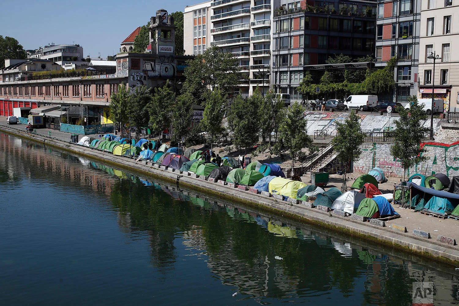 Tents where asylum seekers have set up a makeshift camp line the edge of the Canal Saint-Martin, in Paris, Friday, May 18, 2018. (AP Photo/Francois Mori)