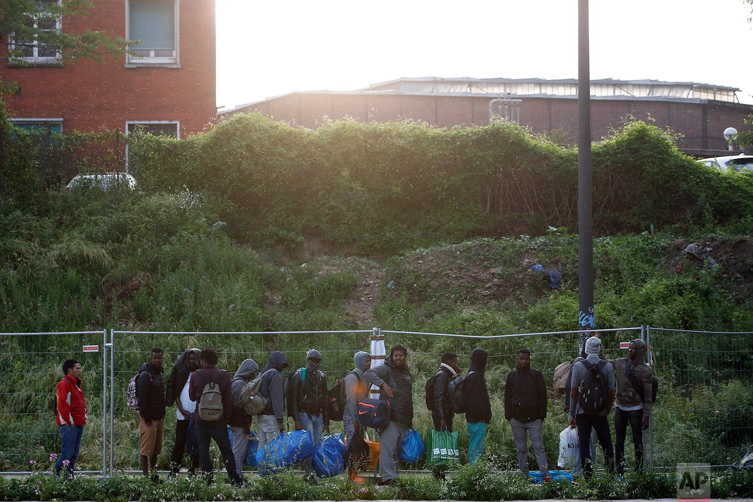 Migrants line up in a makeshift camp during its evacuation, in Paris, Wednesday, May 30, 2018. (AP Photo/Thibault Camus)