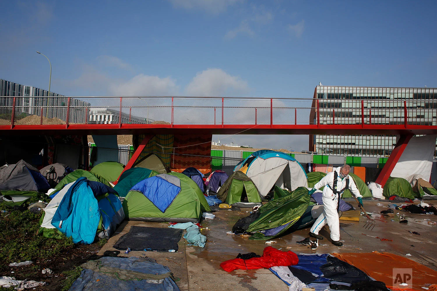 A town hall worker drags away a tent during the clearing of a migrant makeshift camp, in Paris, Wednesday, May 30, 2018. (AP Photo/Thibault Camus)