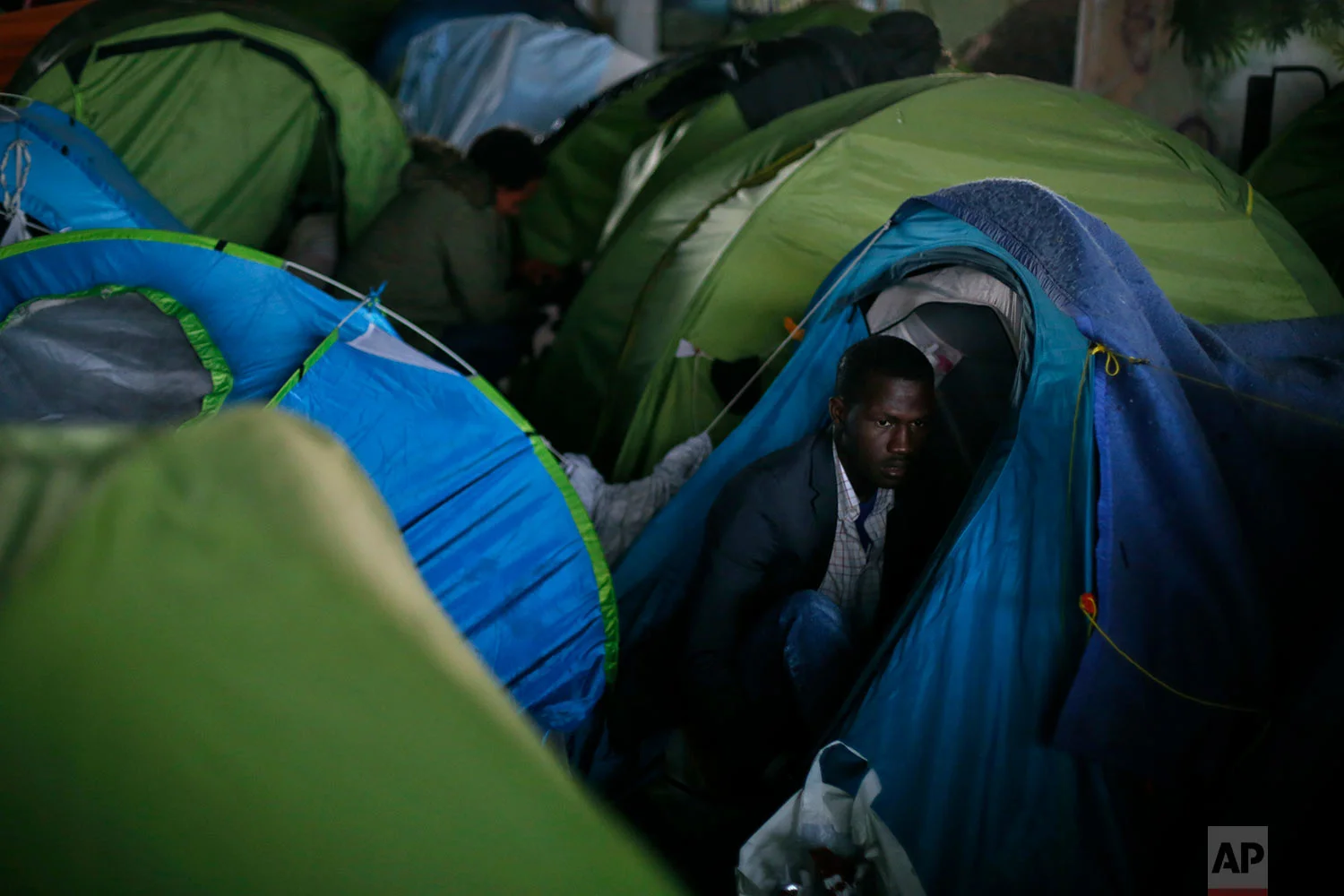 A migrant is shown in his tent during the evacuation of a makeshift camp, in Paris, Wednesday, May 30, 2018. (AP Photo/Thibault Camus)