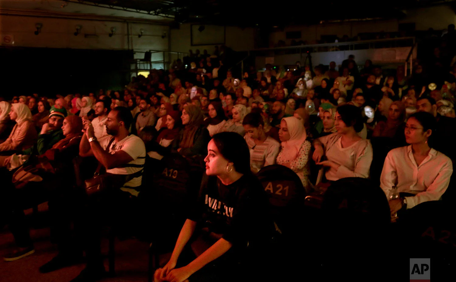 People watch a marionette performance showing Umm Kalthoum, the most famed singer of classical Arabic music, marionettes made by Egyptian artist Mohamed Fawzi Bakkar, at the El Sawy Cultural Center, in Cairo, Egypt, May 3, 2018 . (AP Photo/Nariman El-Mofty)