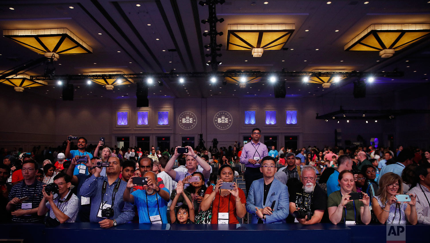 Parents and supporters gather in front of the stage to photograph the medal winners advancing to the final round of the Scripps National Spelling Bee in Oxon Hill, Md., Wednesday, May 30, 2018. (AP Photo/Carolyn Kaster)