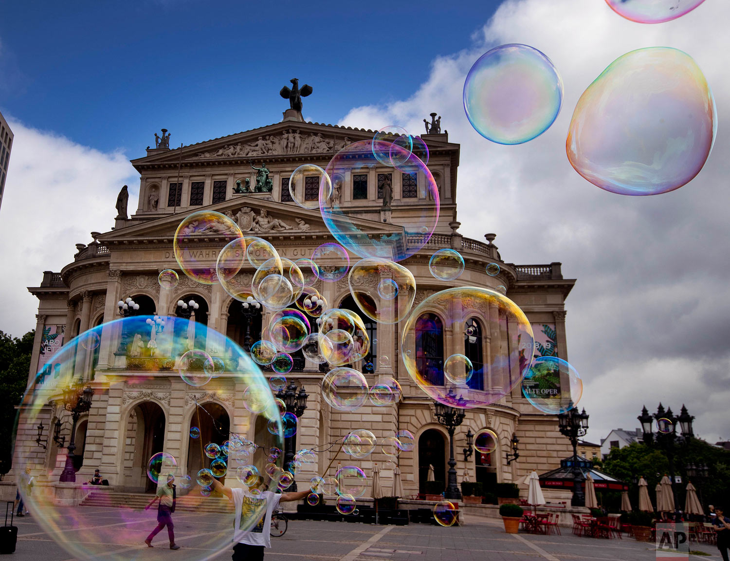 A bubble artist performs with soap bubbles in front of the Old Opera in Frankfurt, Germany, Friday, June 1, 2018. (AP Photo/Michael Probst)