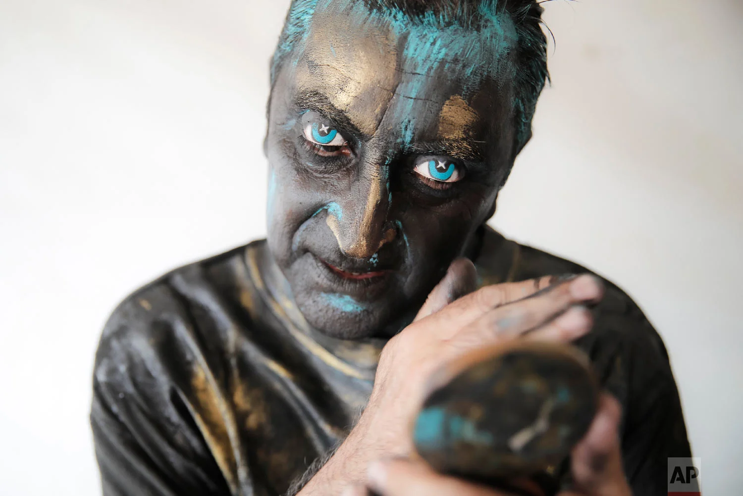 Portuguese artist Antonio Santos checks his make-up during the Living Statues International Festival, in Bucharest, Romania on Sunday, May 27, 2018. (AP Photo/Vadim Ghirda)