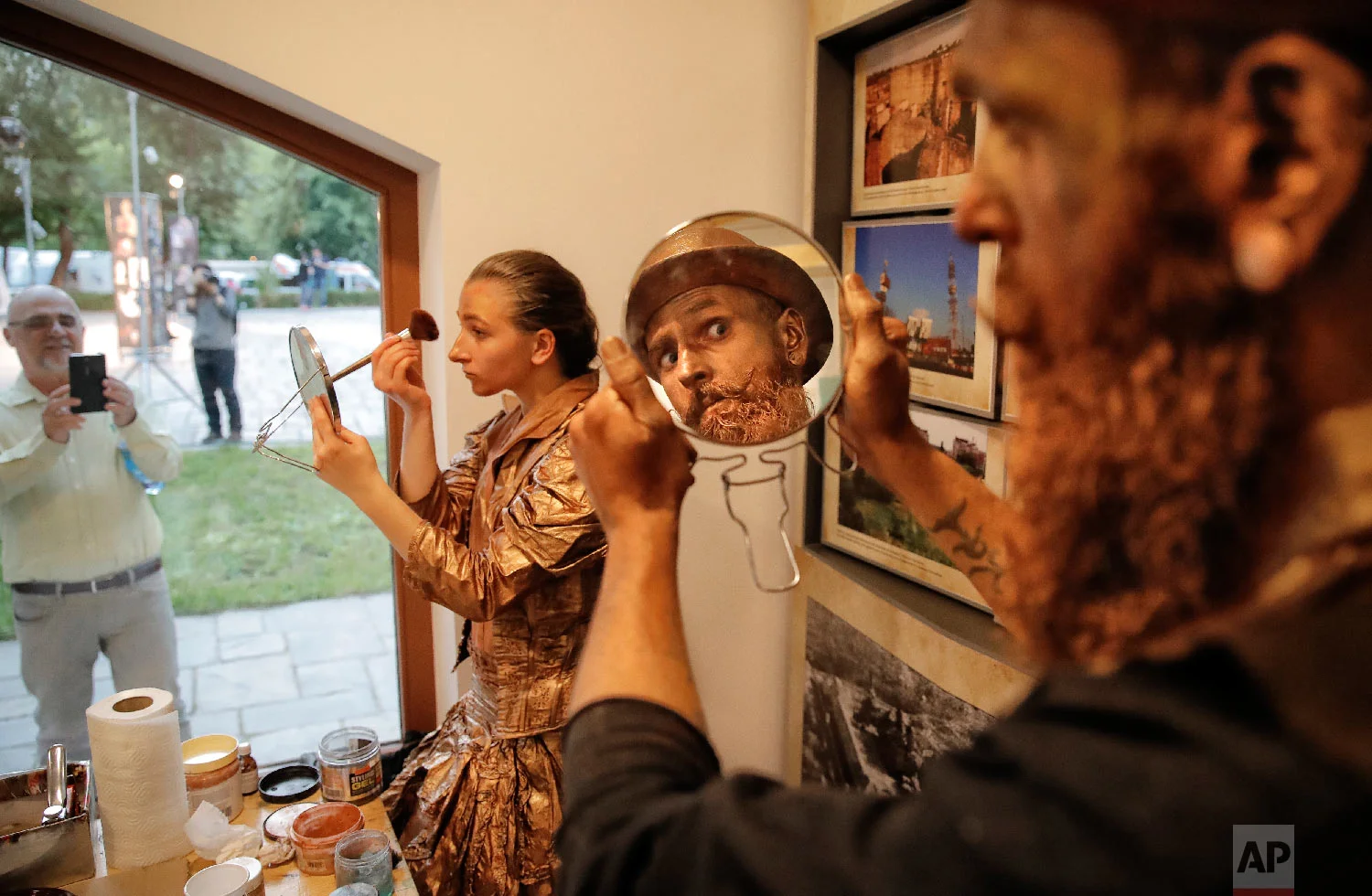 Artists of Ukraine's Artel Myth theatre apply make-up before performing in the Living Statues International Festival, in Bucharest, Romania in Tuesday, May 22, 2018 (AP Photo/Vadim Ghirda)