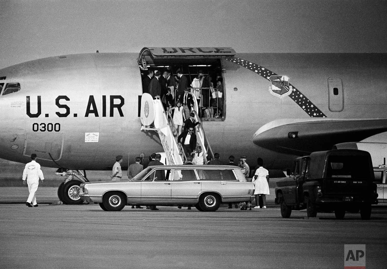 Children of Sen. and Mrs. Robert F. Kennedy arrive, June 5, 1968 at Andrews Air Force Base, Maryland near Washington, after an evening flight from Los Angeles where their father was shot earlier in the day. Coming down the ramp of an Air Force plane are, from bottom, Kerry, 8 assisted by an unidentified aide; Michael, 10, Courtnay, 11, and David, 13. Others inside plane include astronaut John Glenn, back to camera, assisting Christopher, 4. (AP Photo/Charles Harrity)