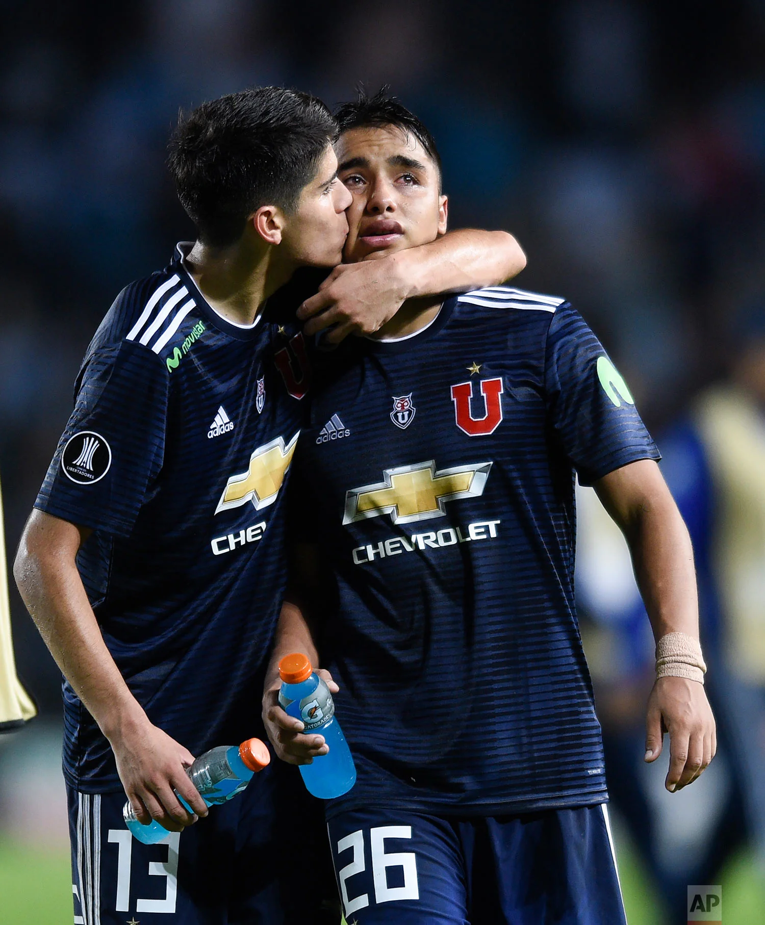 Nicolas Guerra Ruz gets a kiss from teammate Angelo Araos, of Universidad de Chile, after they lost 0-1 to Racing Club a Copa Libertadores soccer match in Buenos Aires, Argentina, Thursday, May 3, 2018.(AP Photo/Gustavo Garello)