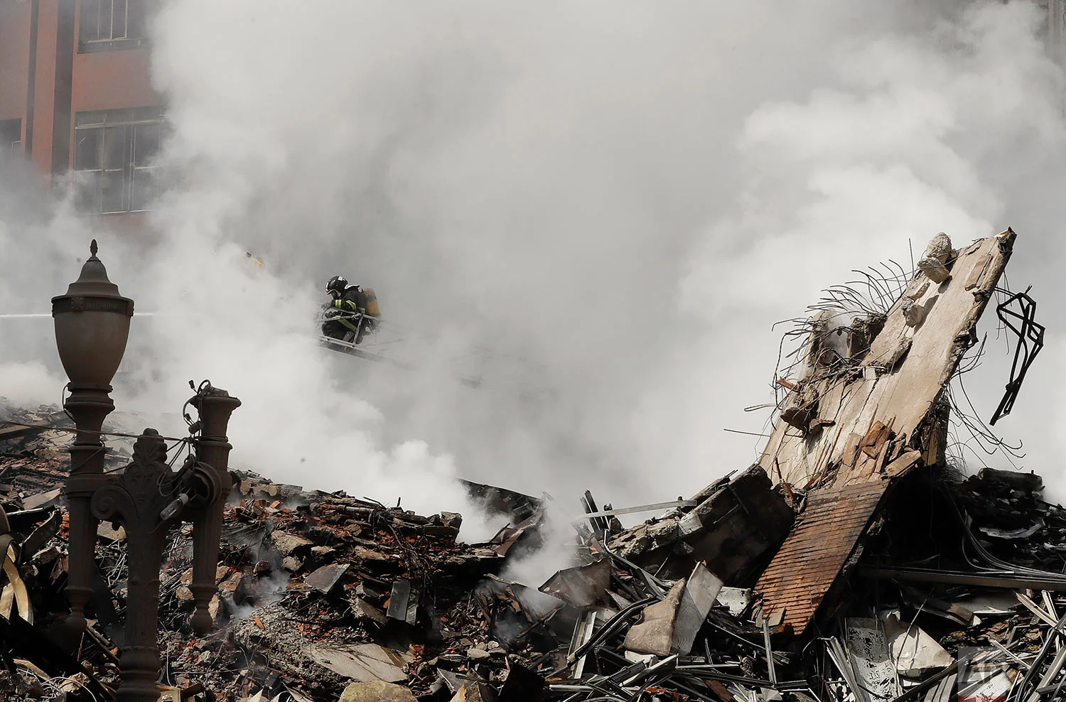 Firefighters work in the the rubble of a building that caught fire and collapsed in Sao Paulo, Brazil, Tuesday, May 1, 2018. The building collapsed as firefighters worked to put out the flames. (AP Photo/Andre Penner)