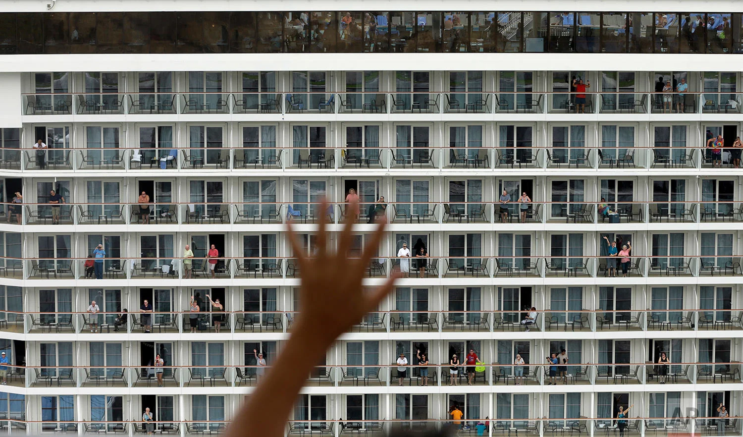 A tourist waves to passengers of the Norwegian Bliss ship as the ship makes its way through the canal, one of the largest ships to ever navigate it, in Agua Clara, Panama, Monday, May 14, 2018. Norwegian Bliss is the largest ship in Norwegian's fleet, with 20 decks and a capacity of about 4,000 passengers. (AP Photo/Arnulfo Franco)