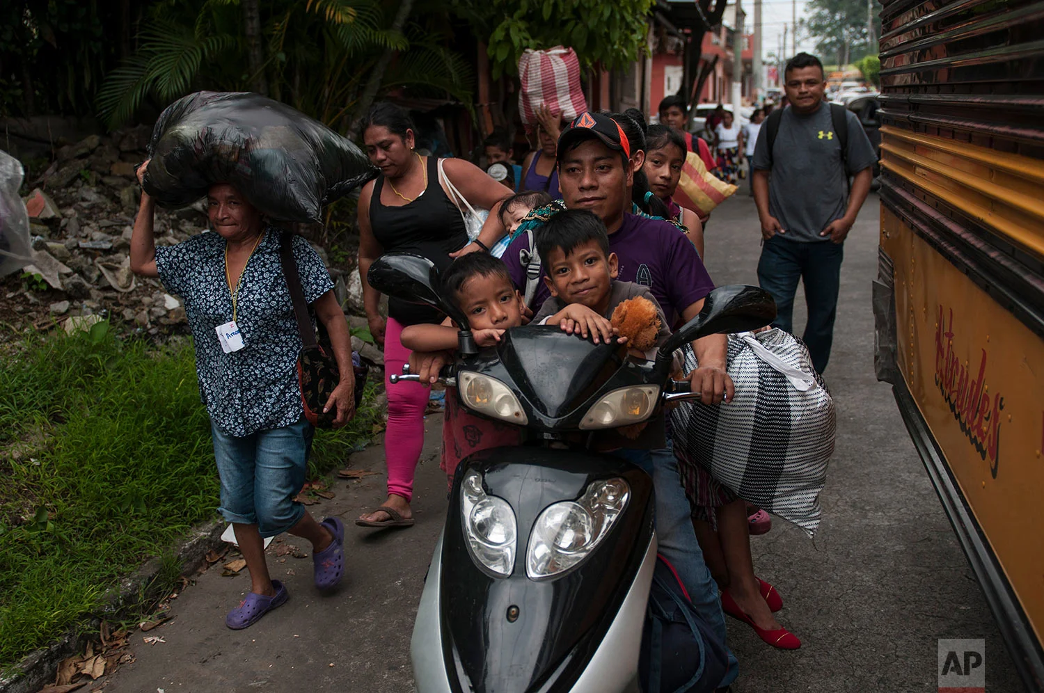 Residents evacuate after a new flow of searing hot volcanic material moved down the slopes of the Volcano of Fire in Escuintla, Guatemala, Tuesday, June 5, 2018. (AP Photo/Oliver de Ros)