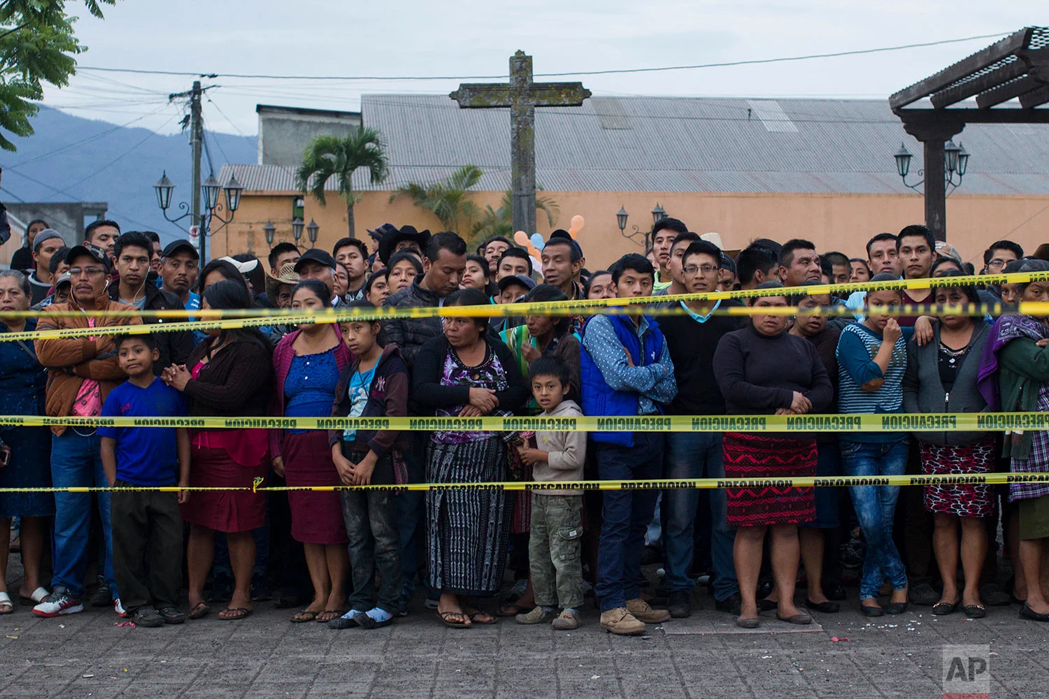 Neighbors stand outside a temporary morgue near Volcan de Fuego or Volcano of Fire in Alotenango, Guatemala, Sunday, June 3, 2018. (AP Photo/Luis Soto)