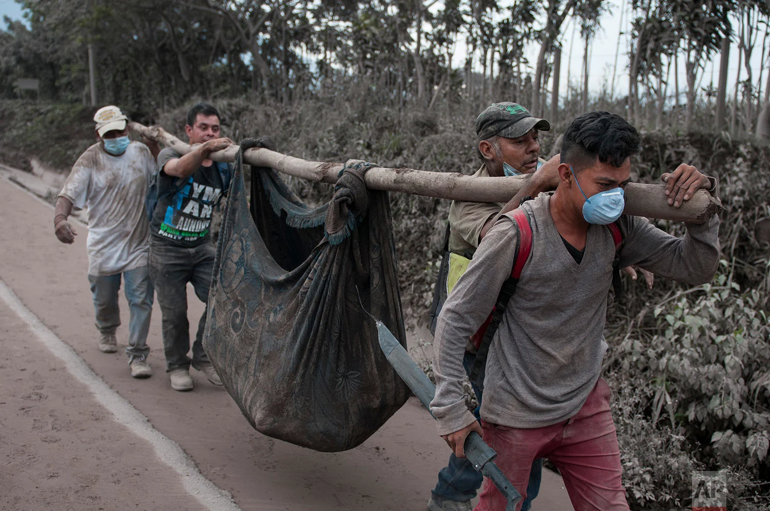 Residents carry a body recovered near the Volcan de Fuego, or "Volcano of Fire," in Escuintla, Guatemala, Monday, June 4, 2018. (AP Photo/Oliver de Ros)