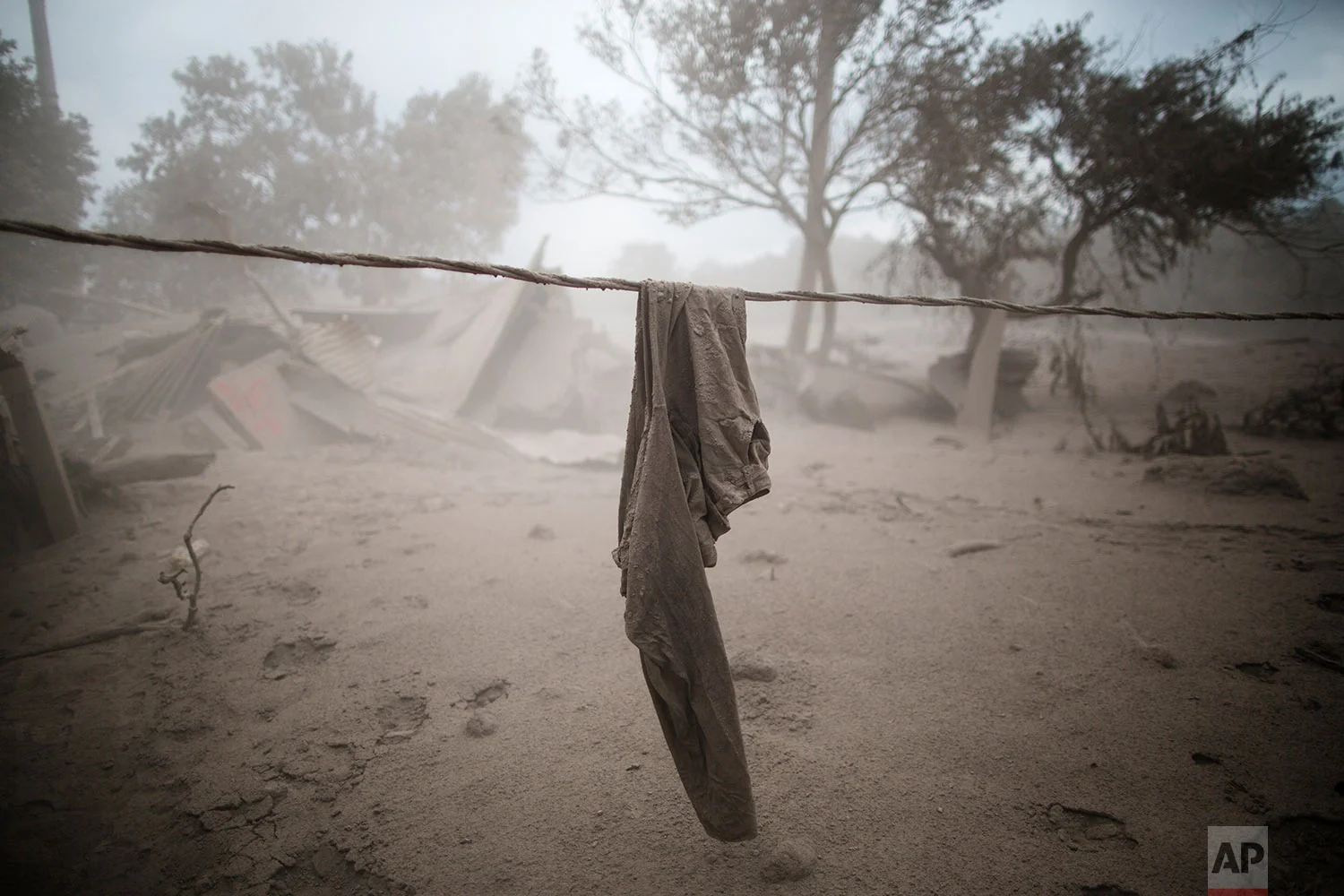 A pair of pants hang near a destroyed home in the disaster zone covered in volcanic ash near the Volcan de Fuego, or "Volcano of Fire," in the El Rodeo hamlet of Escuintla, Guatemala, Tuesday, June 5, 2018. (AP Photo/Rodrigo Abd)