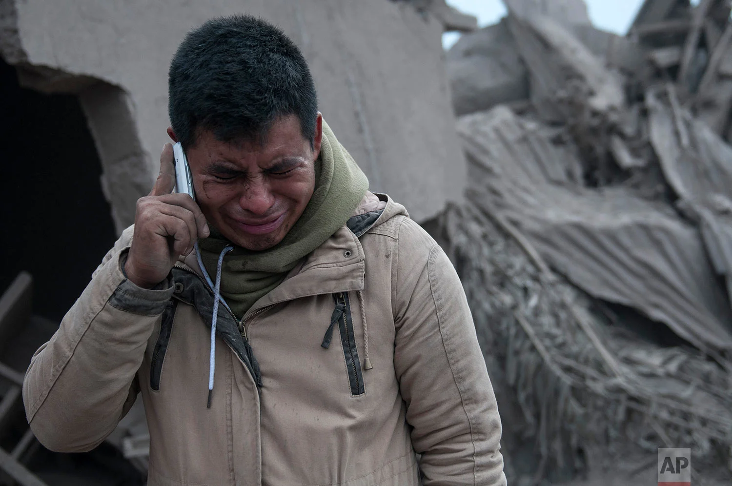 Boris Rodriguez, 24, who is searching for his wife, cries after seeing the condition of his neighborhood, destroyed by the erupting Volcan de Fuego, or "Volcano of Fire," in Escuintla, Guatemala, Monday, June 4, 2018. (AP Photo/Oliver de Ros) 