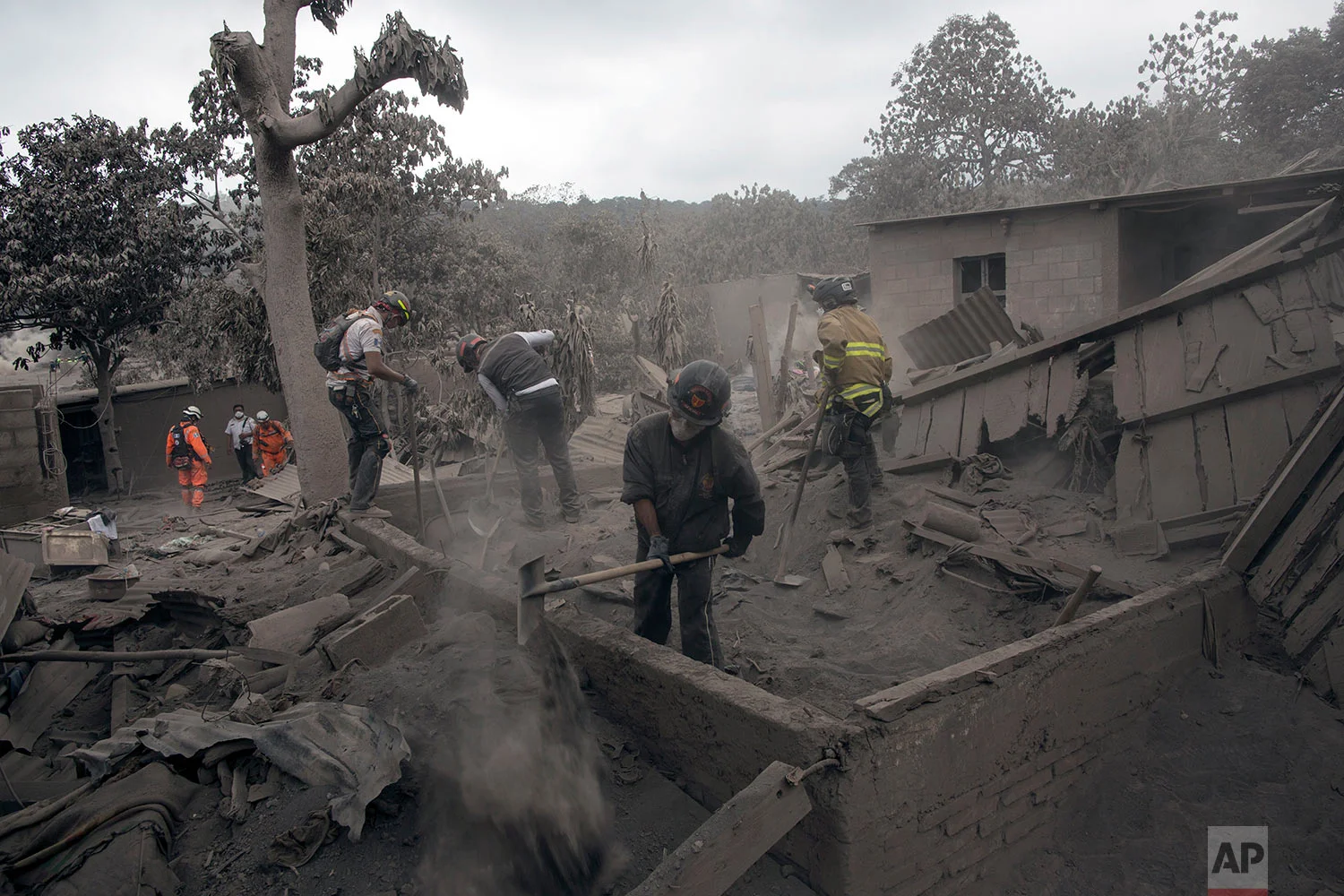 Firefighters work in the disaster zone blanketed in volcanic ash near the Volcan de Fuego, or "Volcano of Fire," in the El Rodeo hamlet of Escuintla, Guatemala, Tuesday, June 5, 2018.&nbsp;&nbsp;(AP Photo/Rodrigo Abd)