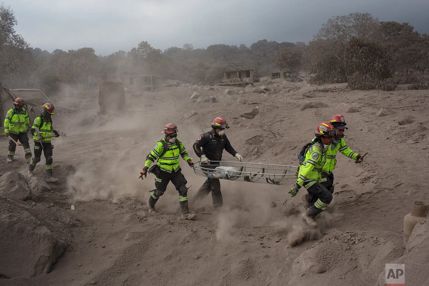 Rescue workers run for cover as the Volcan de Fuego, or "Volcano of Fire," blows more clouds of ash in the El Rodeo hamlet of Escuintla, Guatemala, Tuesday, June 5, 2018. The fiery volcanic eruption on Sunday in south-central Guatemala killed scores…