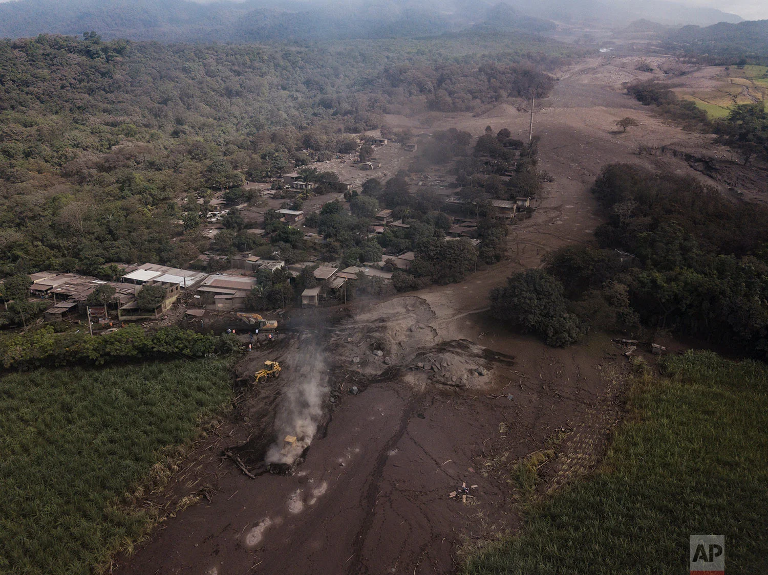 Bulldozers work to remove volcanic ash near the Volcan de Fuego, or "Volcano of Fire," in El Rodeo, Guatemala, Wednesday, June 6, 2018. Rescuers were concerned about possible dangers posed not only by more volcanic flows but also rain. Authorities h…