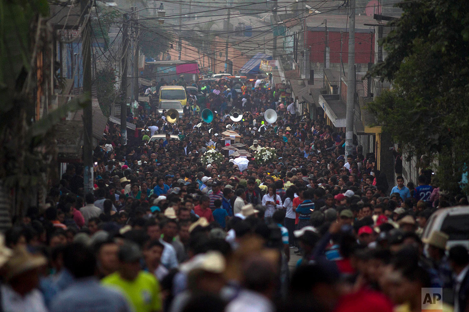 Mourners load the coffins of seven people, who died during the eruption of the Volcan de Fuego, which in Spanish means Volcano of Fire, on their way to the local cemetery of San Juan Alotenango, Guatemala, Monday, June 4, 2018. A fiery volcanic erup…