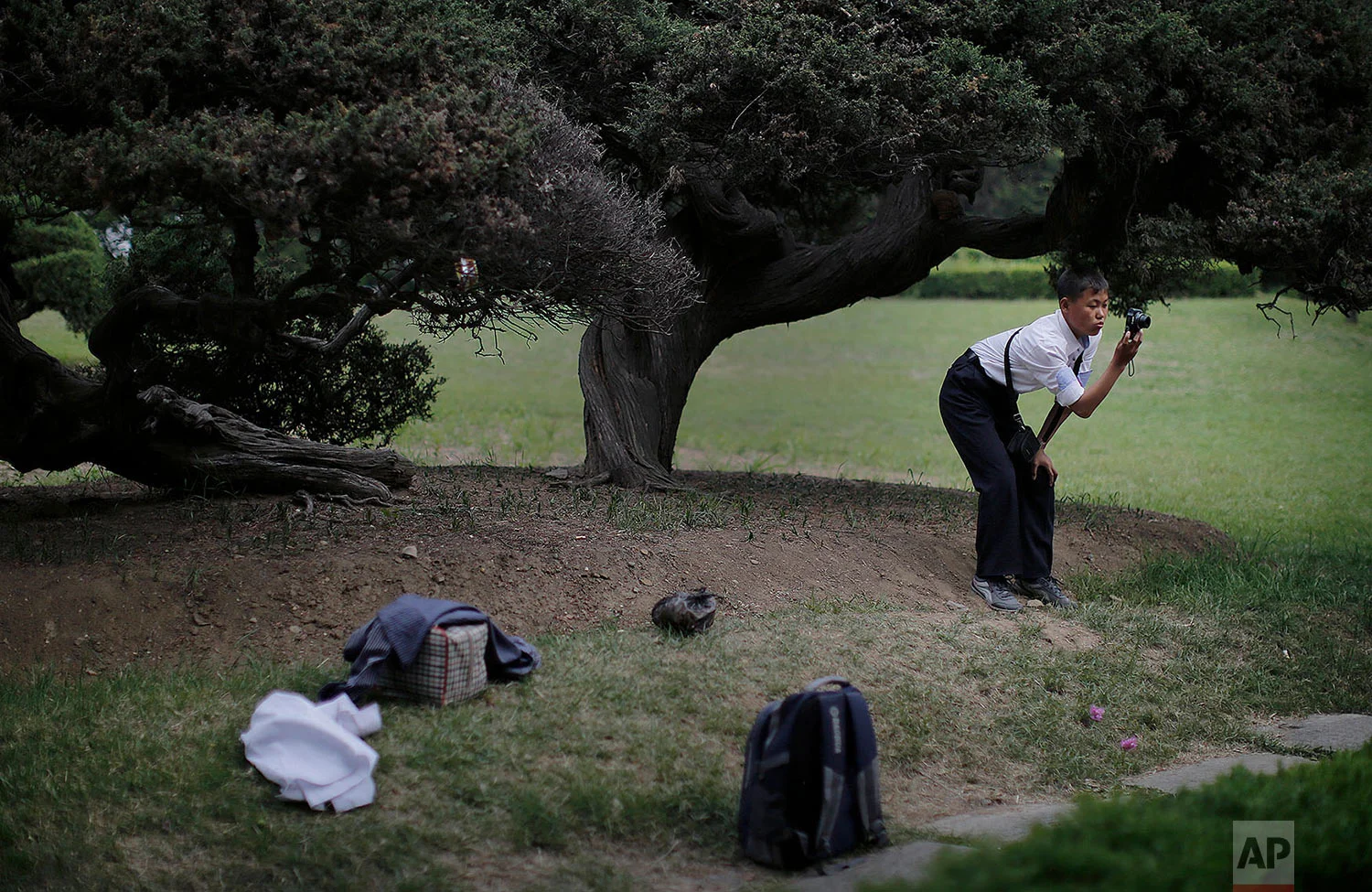 A boy takes a picture of his family at the Moranbong park in central Pyongyang, North Korea, on Sunday, May 3, 2015. (AP Photo/Wong Maye-E)