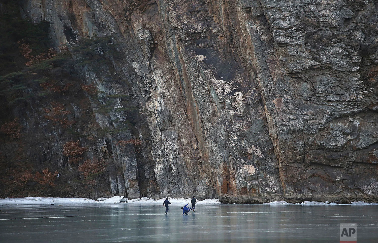 A boy slips while playing on a frozen lake in Sinpyong county, North Hwanghae province, North Korea, on Feb. 20, 2016. (AP Photo/Wong Maye-E)