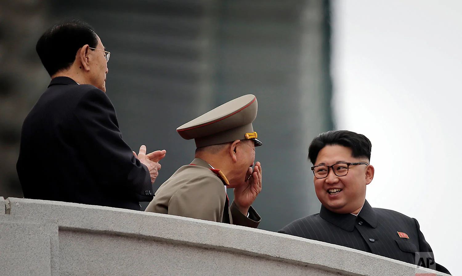 North Korean leader Kim Jong Un, right, smiles at Hwang Pyong So, the top political officer of the Korean People's Army, center, and Kim Yong Nam, the head of North Korea's parliament, left, as they watch a parade at Kim Il Sung Square in Pyongyang, North Korea, on May 10, 2016. (AP Photo/Wong Maye-E)
