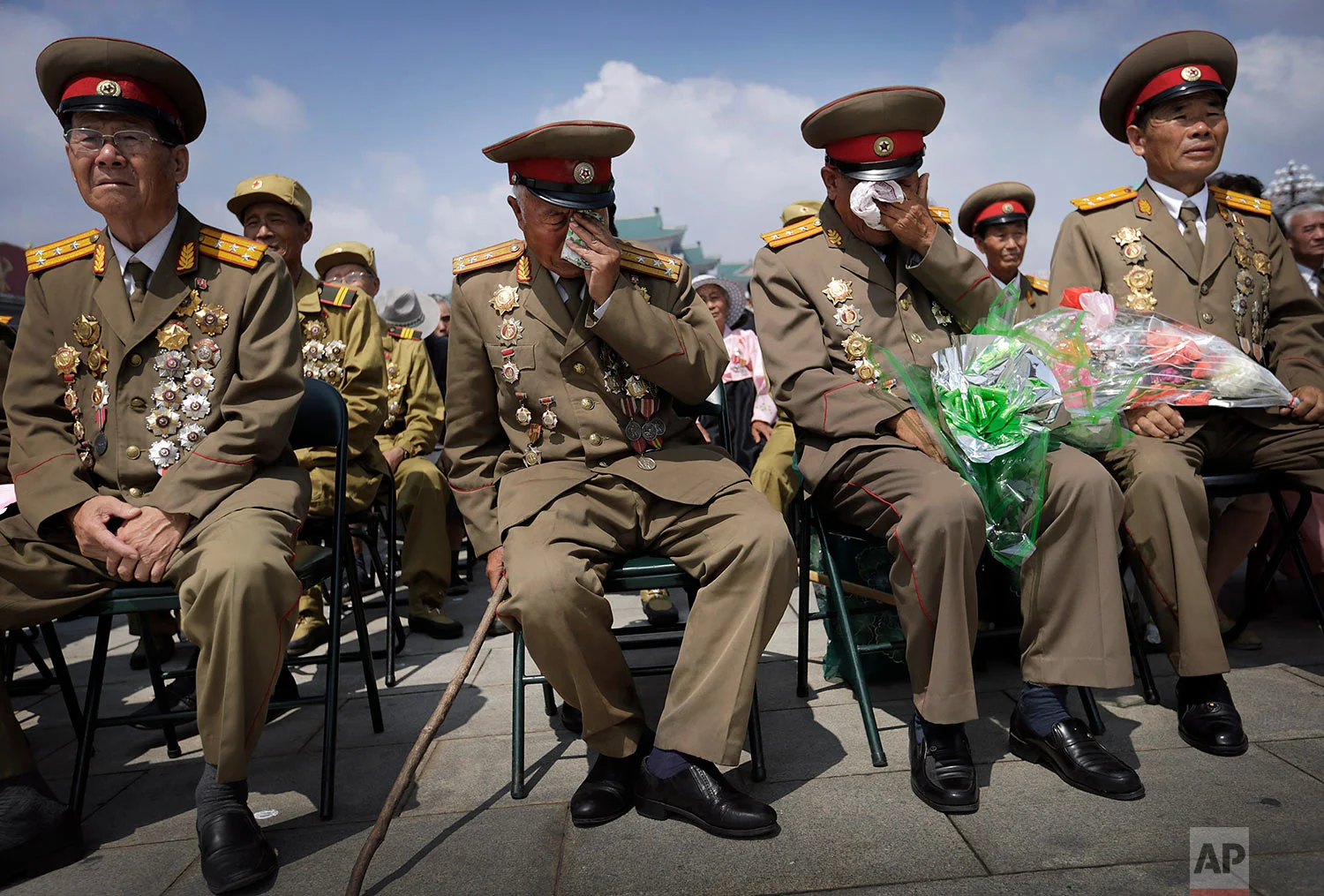 North Korean war veterans express varying degrees of emotion as they watch a parade in Pyongyang's Kim Il Sung Square on July 27, 2014, to mark the 61st anniversary of the armistice that halted fighting in the Korean War. (AP Photo/Wong Maye-E)