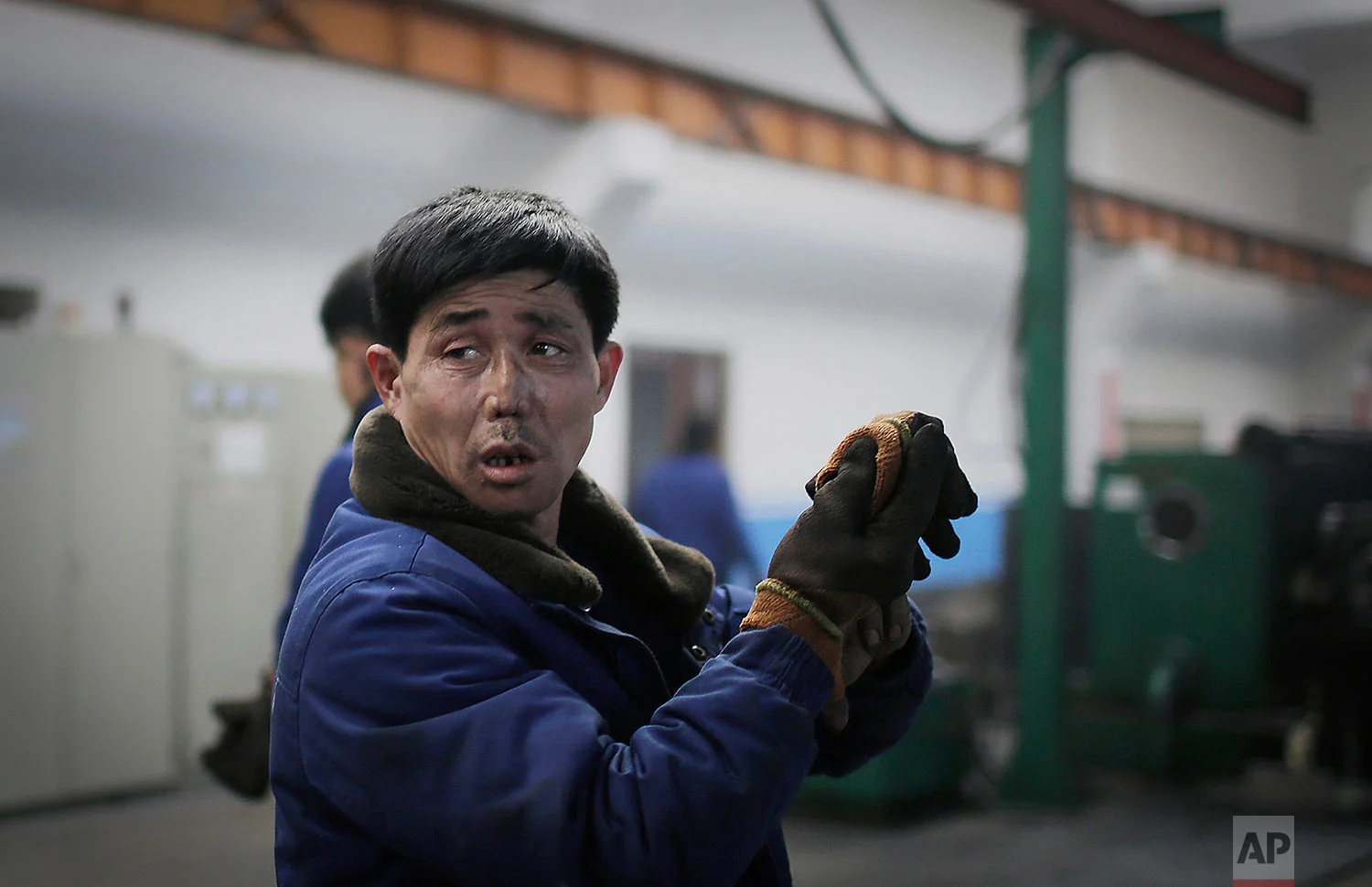 A factory worker takes off his gloves at the Pyongyang 326 Electric Wire Factory in Pyongyang, North Korea, on Jan. 10, 2017. (AP Photo/Wong Maye-E)