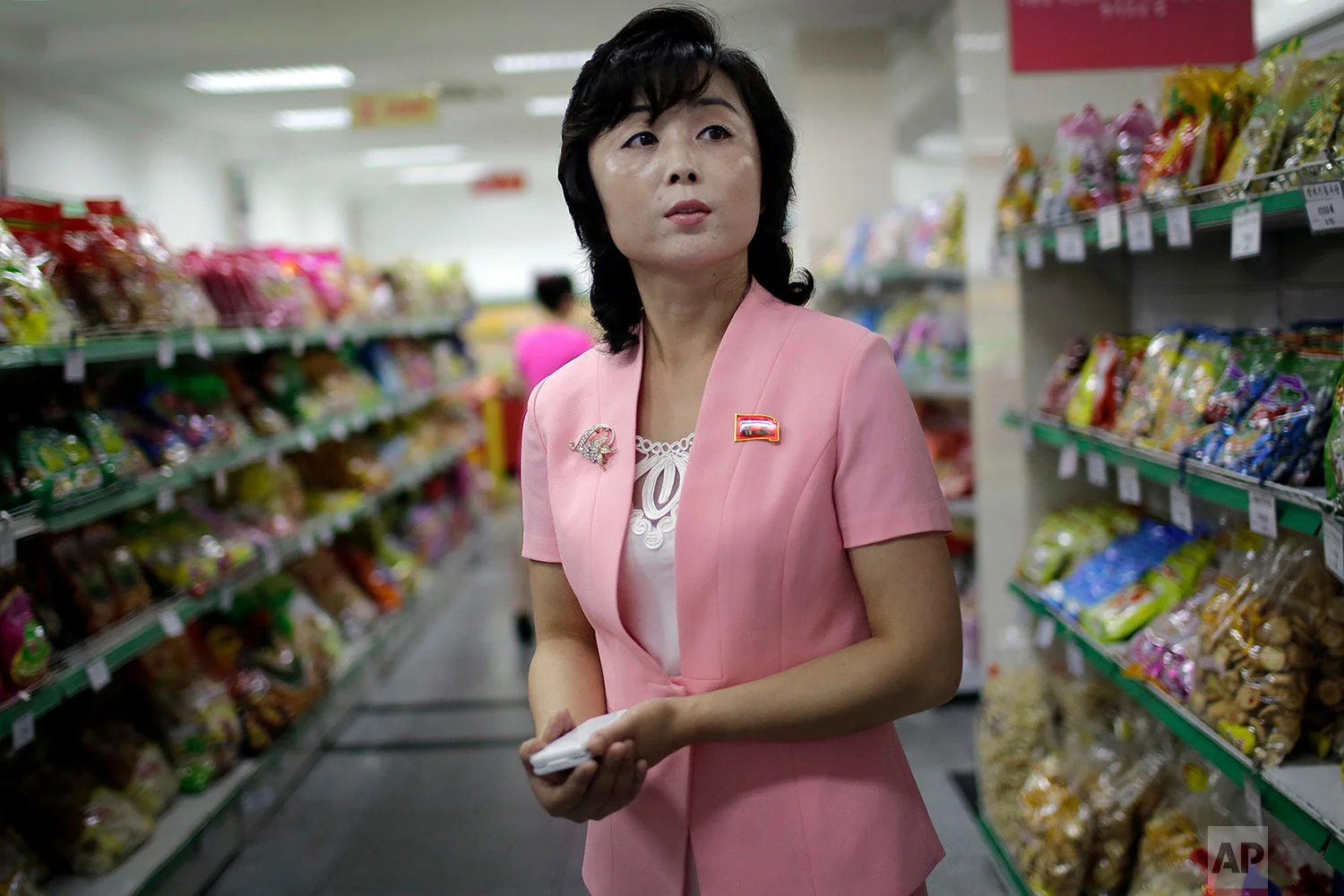 Song Un Pyol, manager at the upscale Potonggang department store in Pyongyang, North Korea, stands in the snacks aisle while being interviewed by The Associated Press on June 19, 2017. Three generations into the ruling dynasty begun by Kim Il Sung, markets have blossomed and a consumer culture is taking root. (AP Photo/Wong Maye-E)