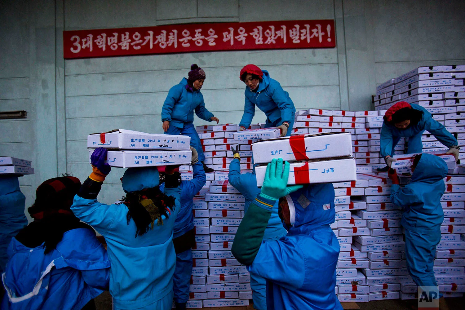 Workers carry boxes of seafood on Nov. 8, 2013, as they load a Chinese transport truck at the Suchae Bong Corp seafood factory in Rajin, North Korea, inside the Rason Special Economic Zone. (AP Photo/David Guttenfelder)