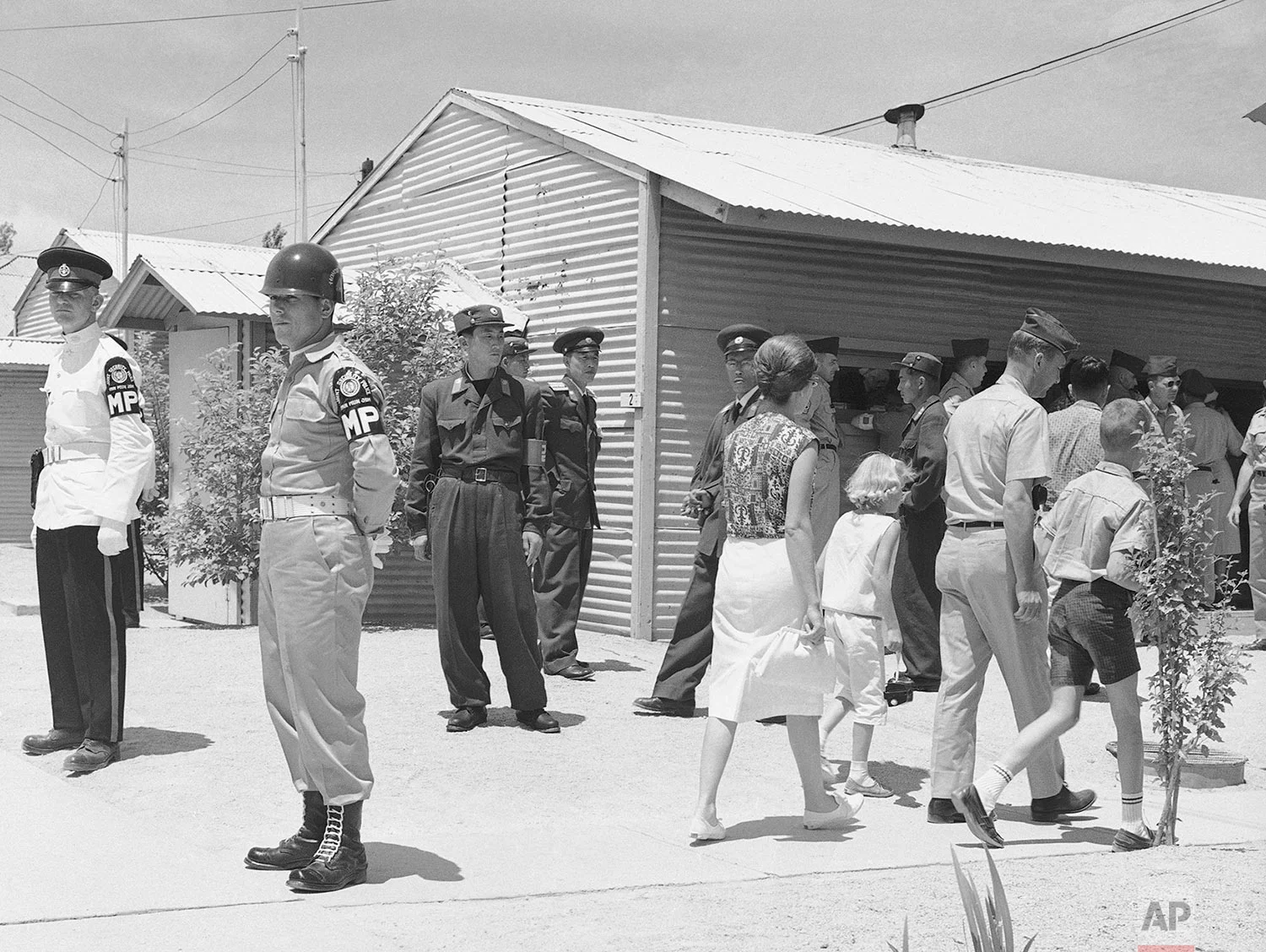 Walking past United Nations and North Korean guards on duty, sightseers flock around the building in which the Military Armistice Commission meets in the Demilitarized Zone at Panmunjom, Korea, on July 8, 1963. (AP Photo/KIM)