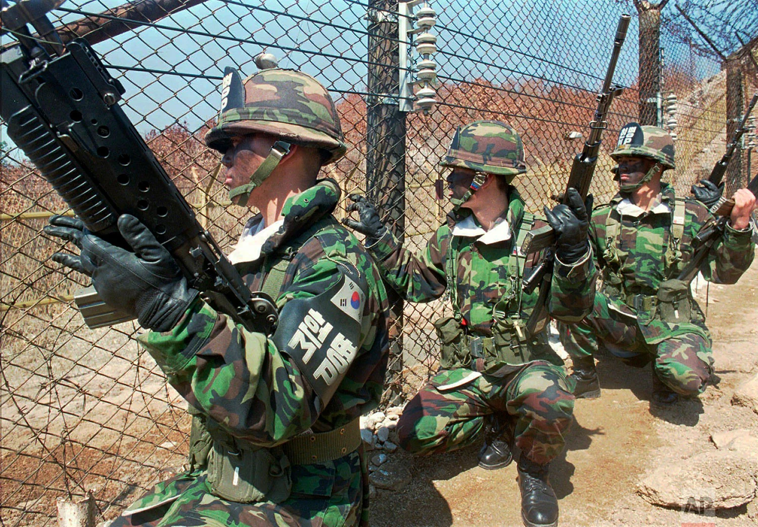 South Korean soldiers take their position along the wire fence in the Demilitarized Zone separating the two Koreas near the truce village of Panmunjom on April 8, 1996, the day after armed North Korean troops marched into the DMZ. (AP Photo/Ahn Young-joon)