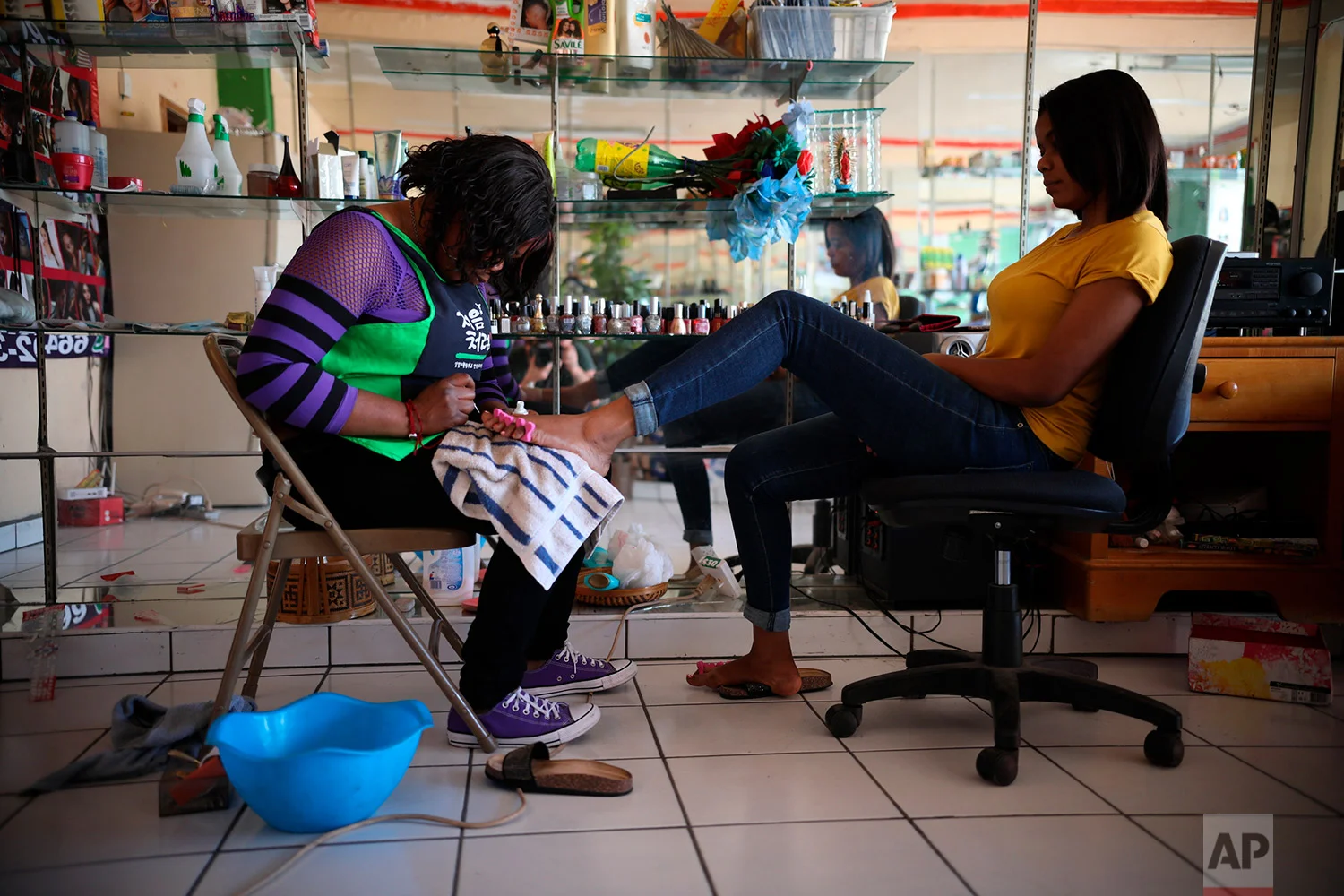 Marie Toussaint gives a pedicure to a customer at her local beauty salon in downtown Tijuana, Mexico, May 5, 2018. (AP Photo/Emilio Espejel)