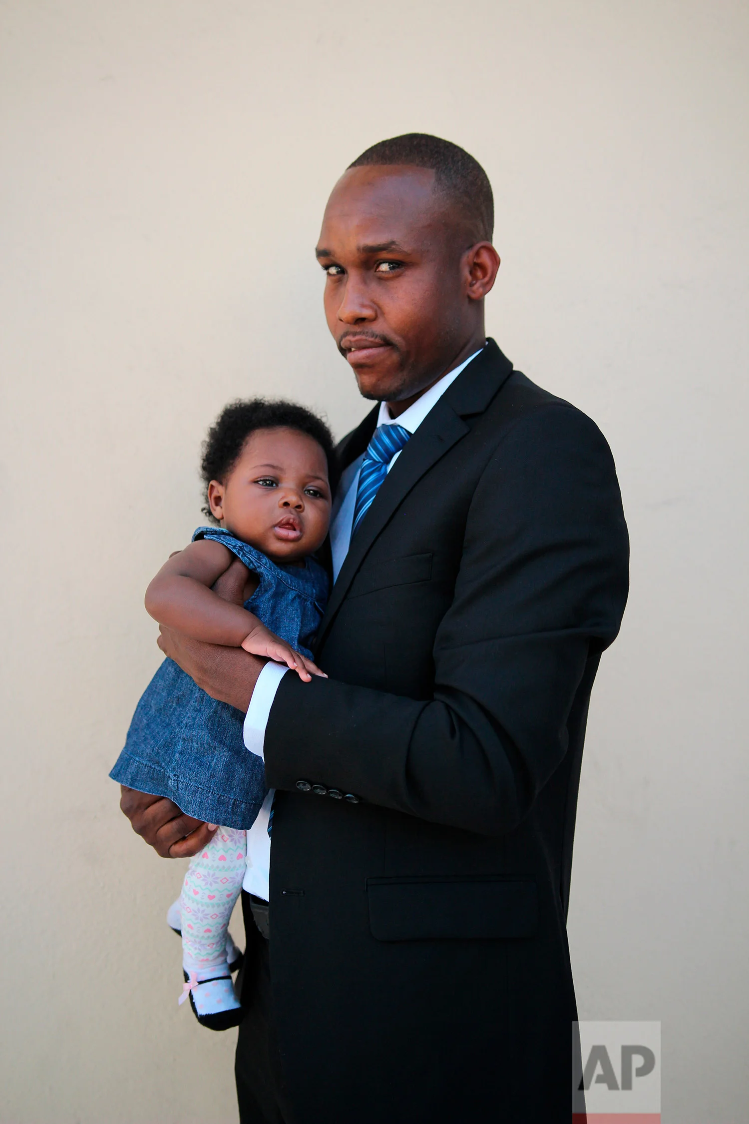 Groom-to-be Jeremy Rebien, 31, poses for a portrait with his daughter, who was born in Mexico. before his wedding at the First Baptist Church of Tijuana, Mexico. (AP Photo/Emilio Espejel)