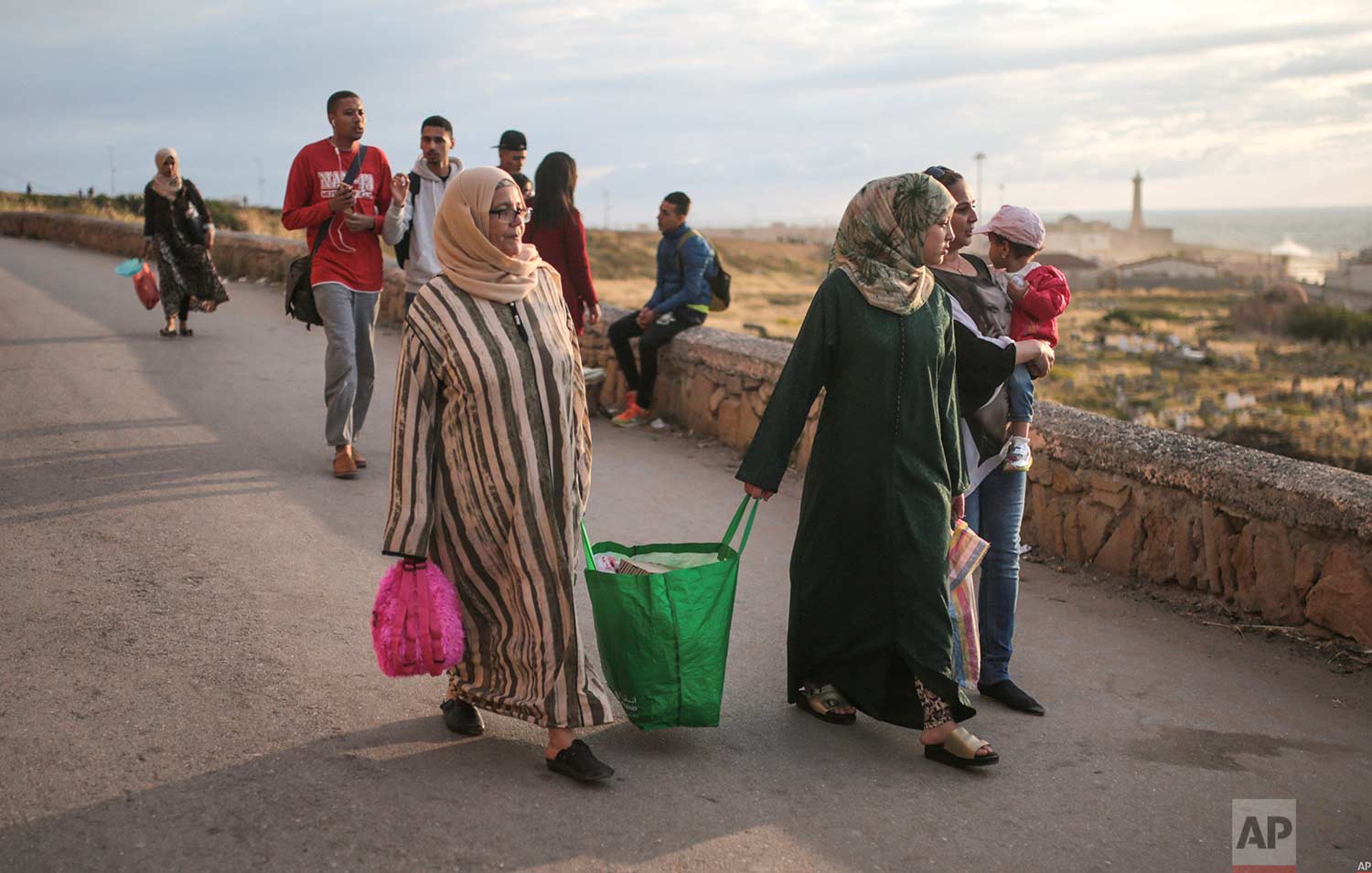  People carry bags of food as they arrive to break their fast in the holy month of Ramadan, on Rabat beach, Morocco, Saturday, June 9, 2018. (AP Photo/Mosa'ab Elshamy) 
