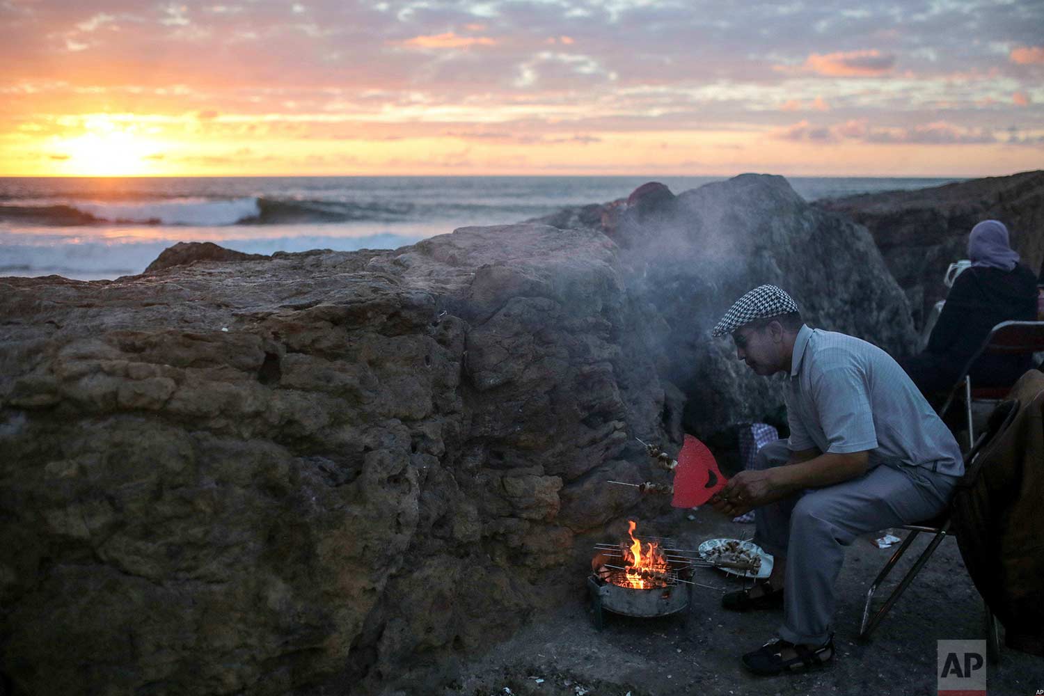  A man grills meat for his family on the beach to break their fast the holy month of Ramadan, in Rabat, Morocco, Saturday, June 9, 2018. (AP Photo/Mosa'ab Elshamy) 