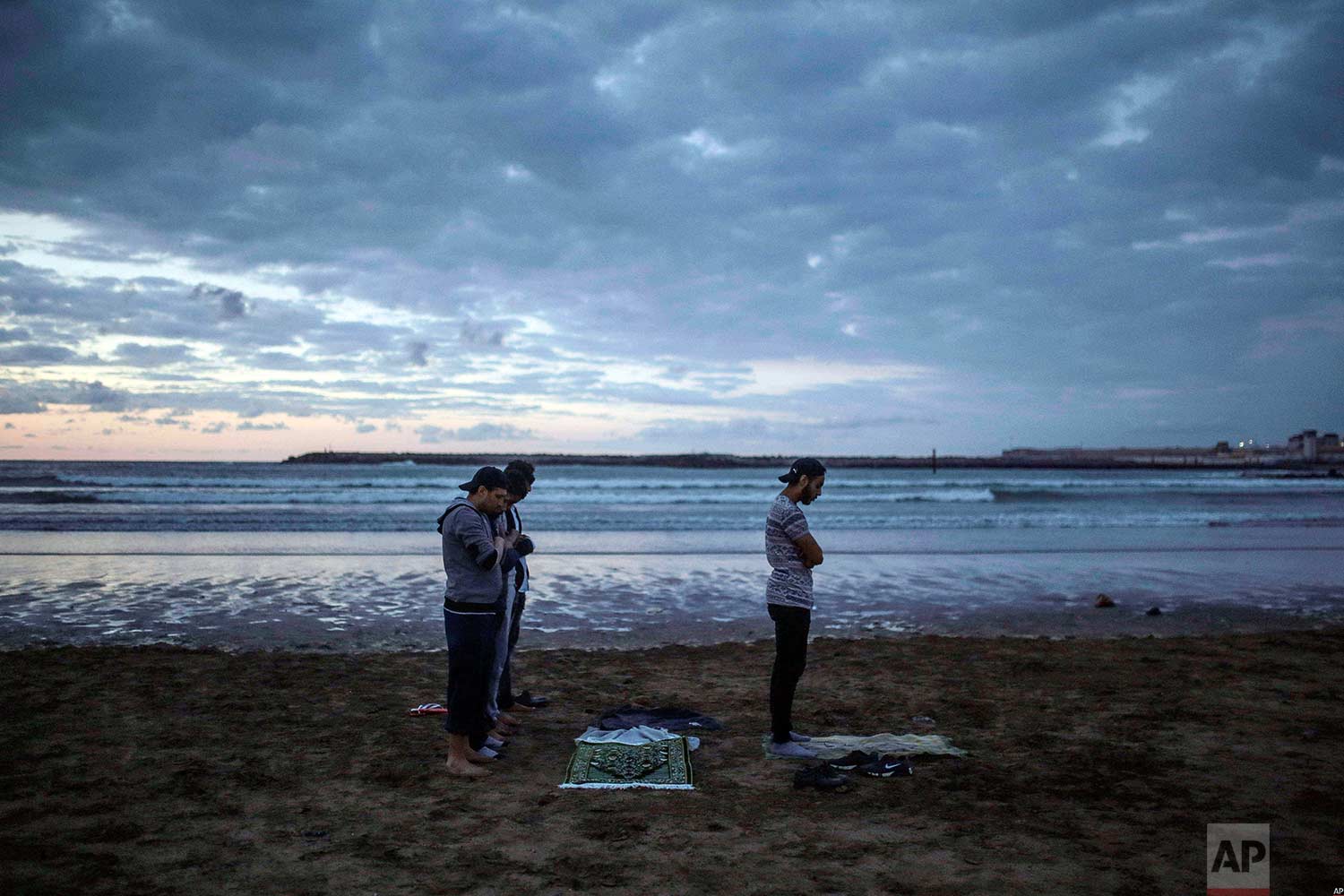  Men pray sunset prayers after breaking their fast on the beach in the holy month of Ramadan, Rabat, Morocco, Saturday, June 9, 2018. (AP Photo/Mosa'ab Elshamy) 