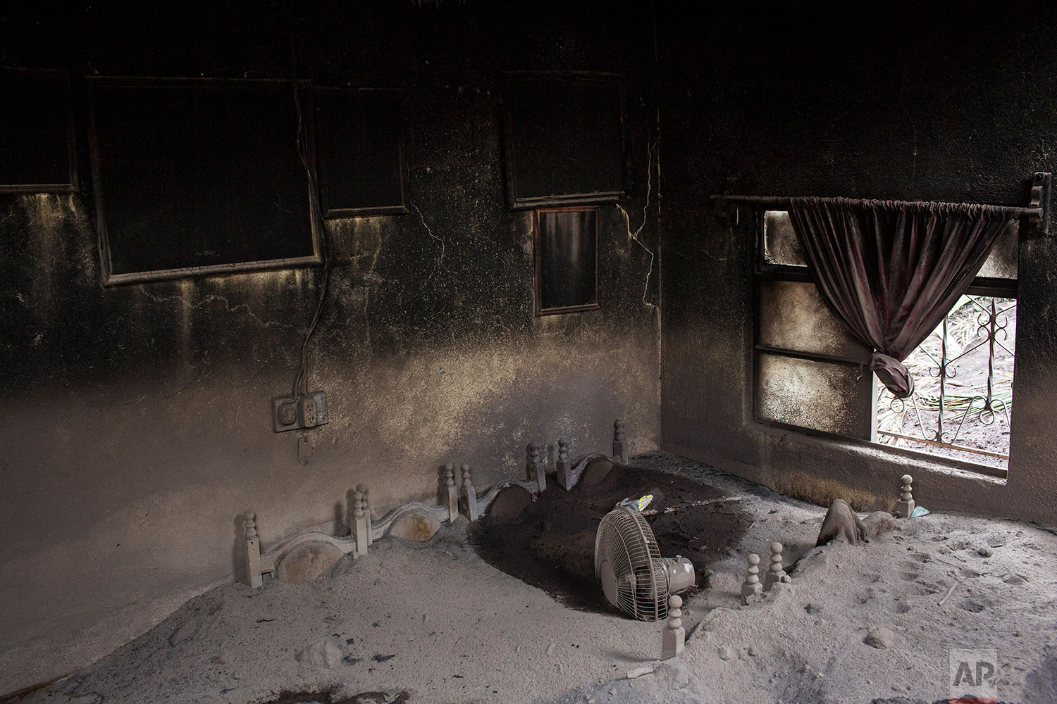  This June 8, 2018 photo shows a dining room set interred in a mass of volcanic ash spewed by the Volcan de Fuego or Volcano of Fire, in San Miguel Los Lotes, Guatemala. (AP Photo/Rodrigo Abd) 